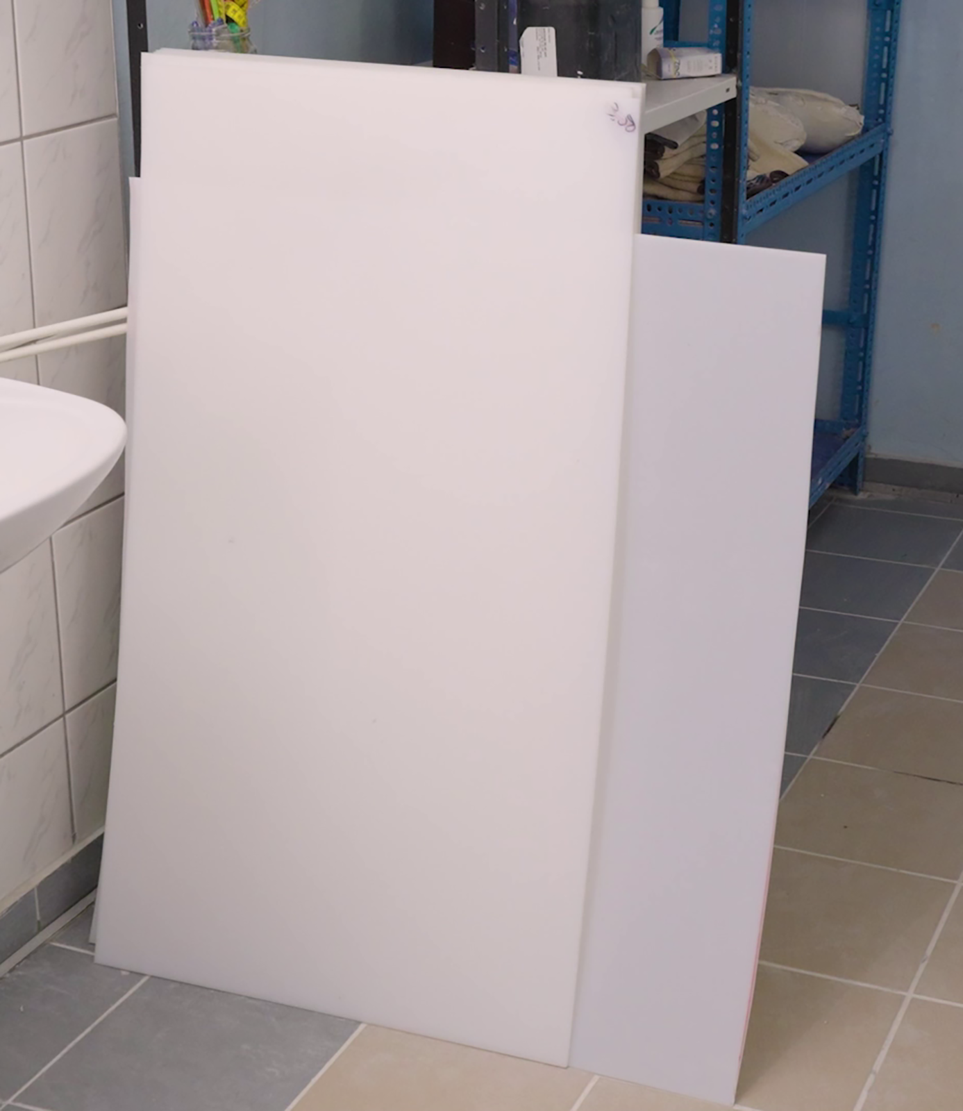 Materiał przestawia kilka prostokątnych arkuszy polietylenu opartych o regał.