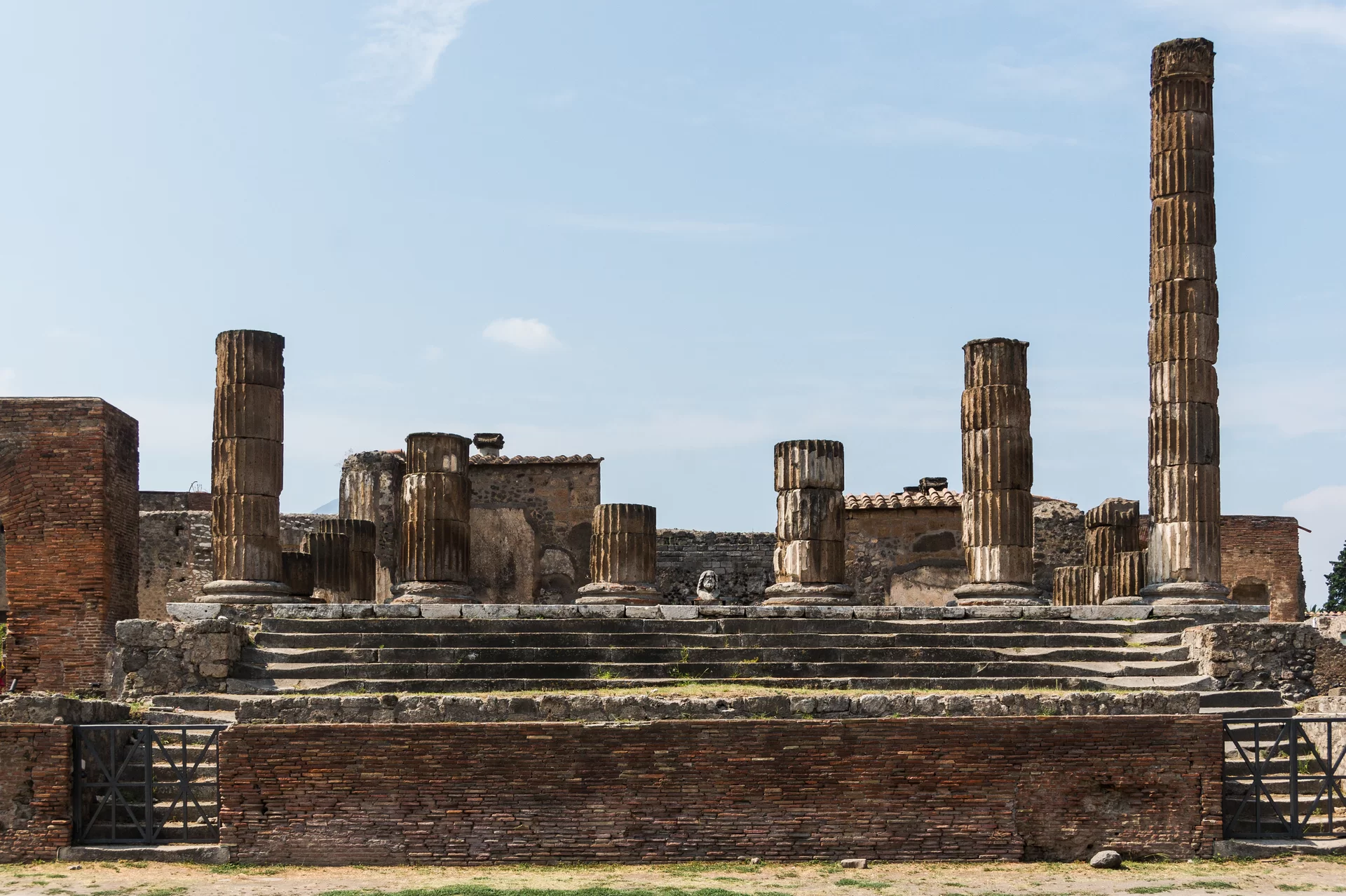 Ruiny Świątyni Jowisza w Pompejach - widoczny kompleks fragmentów kolumn, ścian i schodów.