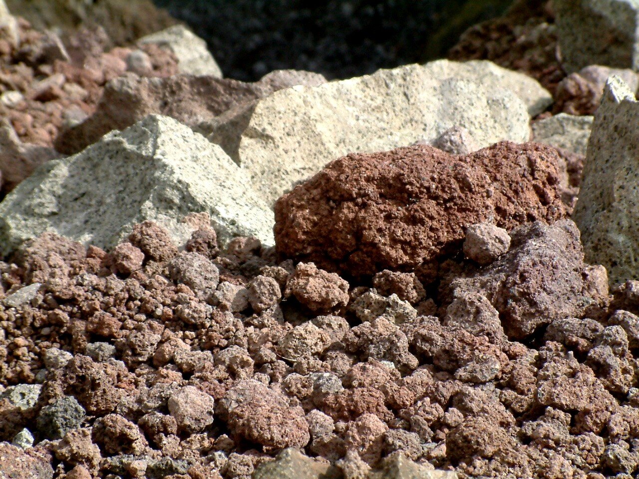 Zdjęcie przedstawia tufy. Jest to porowata skała o nieregularnym kształcie. Ma jasną lub brązową barwę.