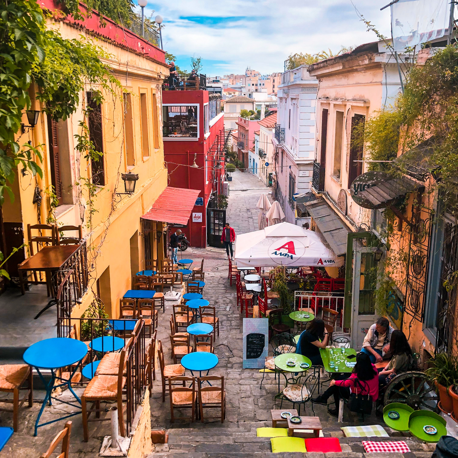 Na zdjęciu widoczna jest spokojna, mała i przyjemna dzielnica. Znajduje się w niej wąska i ładna ulica. W tej dzielnicy jest dużo restauracji. Budynki są niskie i stare.  