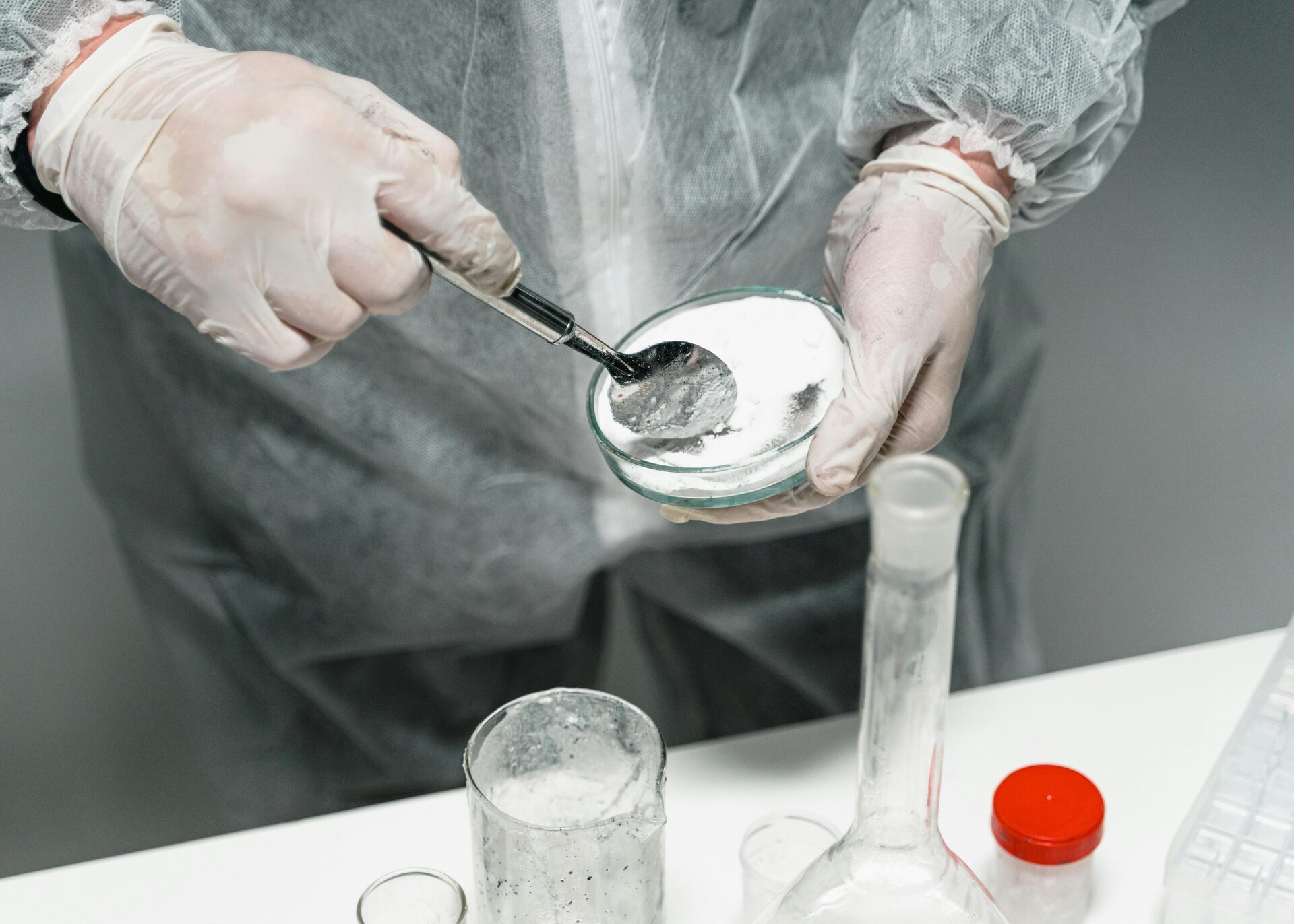 Klasyfikacja surowców według właściwości chemicznych. Drugie zdjęcie przedstawia surowiec podczas wykonywania testów chemicznych.