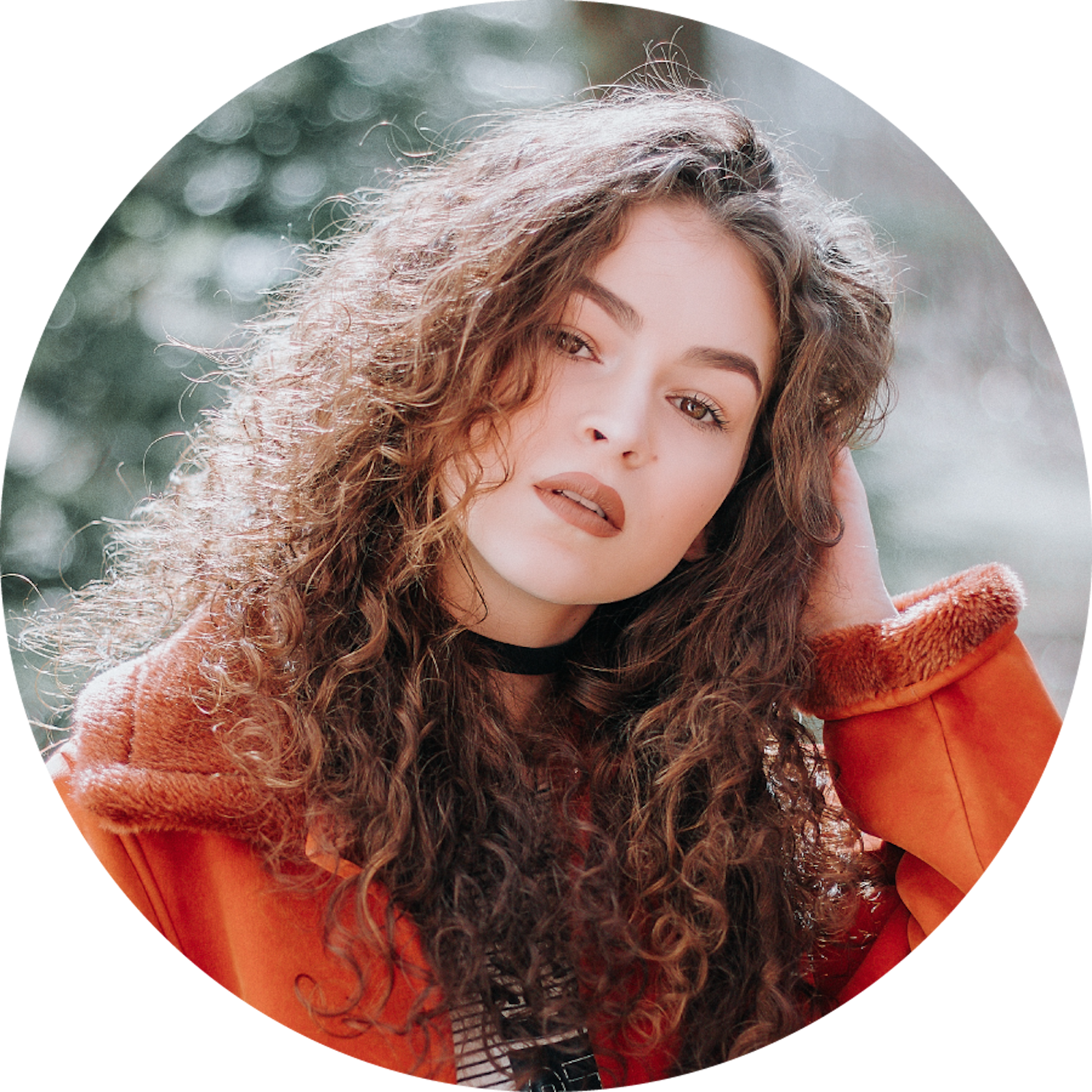 Ilustracja przedstawia młodą kobietę o brązowych, kręconych włosach.