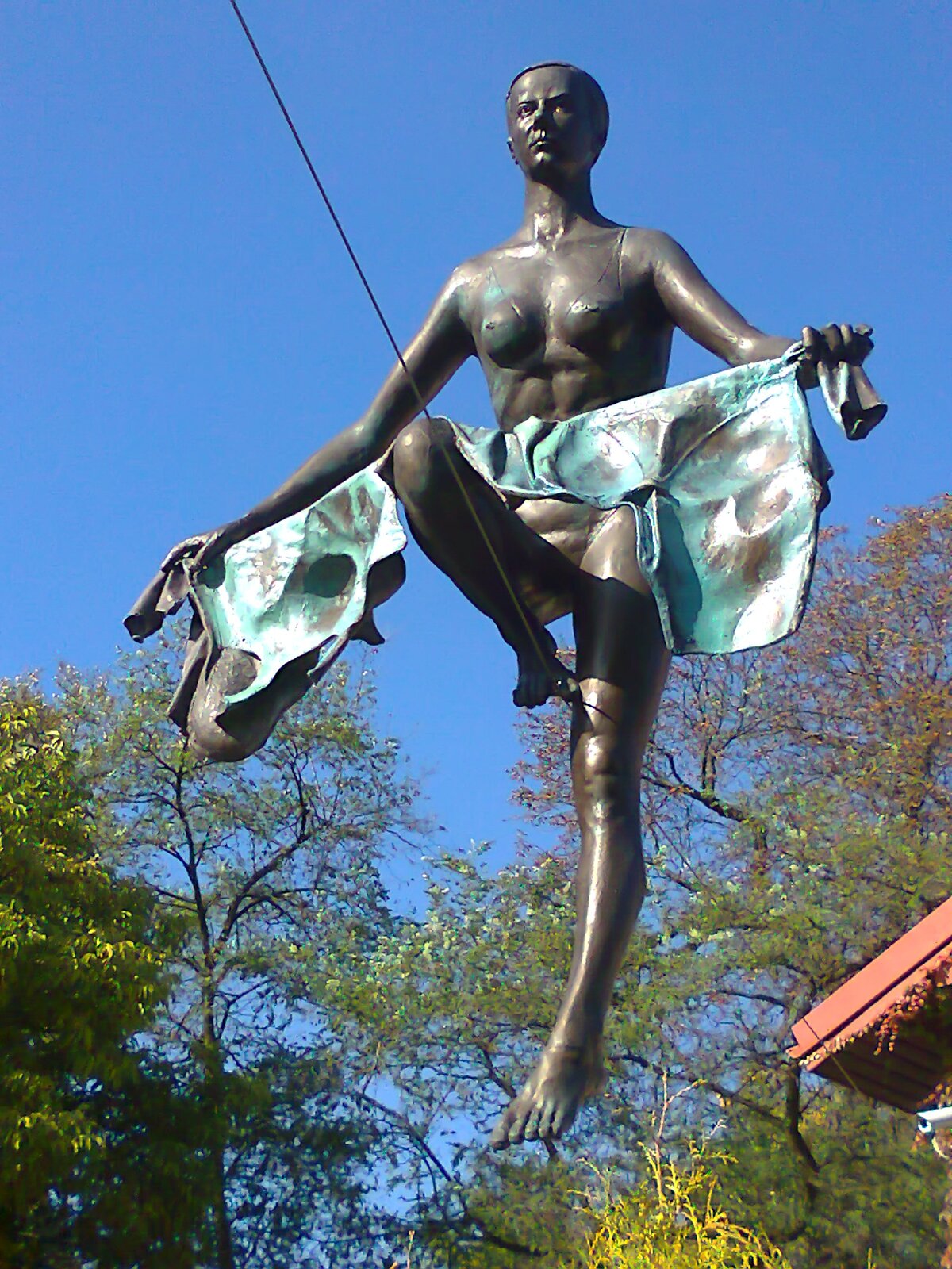 Ilustracja przedstawia rzeźbę Jerzego Jotki Kędziory pt. „Fetysz Dejaniry”. Rzeźba obrazuje nagą kobietę, przechodzącą po zawieszonej na wysokości linie. W rękach trzyma rozciągnięty materiał.