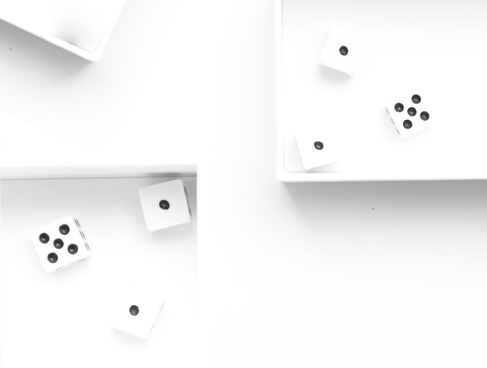 Grafika przedstawia oświetlenie typu High key. W lewym dolnym rogu zdjęcia znajdują się w pudełku trzy kostki do gry z piątką i dwoma jedynkami. Tło za kostkami jest częściowo białe, częściowo szare. W prawym, górnym rogu zdjęcia znajdują się w pudełku także trzy kostki do gry z piątką i dwoma jedynkami. Tło za kostkami jest białe.