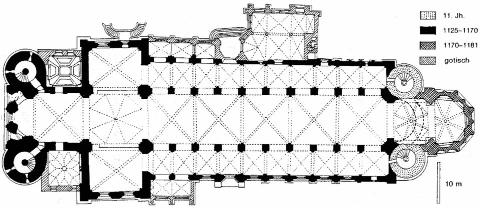 Ilustracja o kształcie poziomego prostokąta przedstawia czarno‑biały rysunek planu kościoła Świętego Piotra w Wormacji na terenie Niemiec. Czarną grubą linią zaznaczono zewnętrzne ściany trójnawowej budowli z wieżami wejściowymi po lewej, wschodniej stronie, za transeptem, za którym jest prezbiterium zamknięte apsydą. Od strony zachodniej znajdują się po bokach dwie okrągłe wieże. Wejście do kościoła jest półkoliste. U góry, po prawej, znajduje się legenda z datami, wyjaśniającymi kolejne etapy budowy.