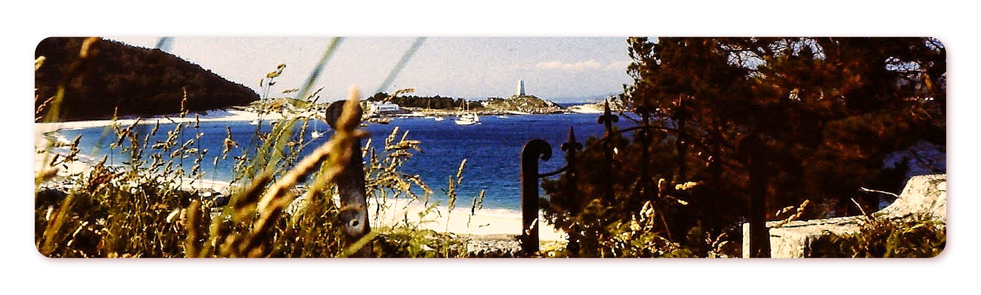 Zdjęcie przedstawia plażę Rodas na wybrzeżu Oceanu Atlantyckiego. Widoczna jest piaszczysta plaża otoczona zielenią. W tle miasteczko na nabrzeżu. 