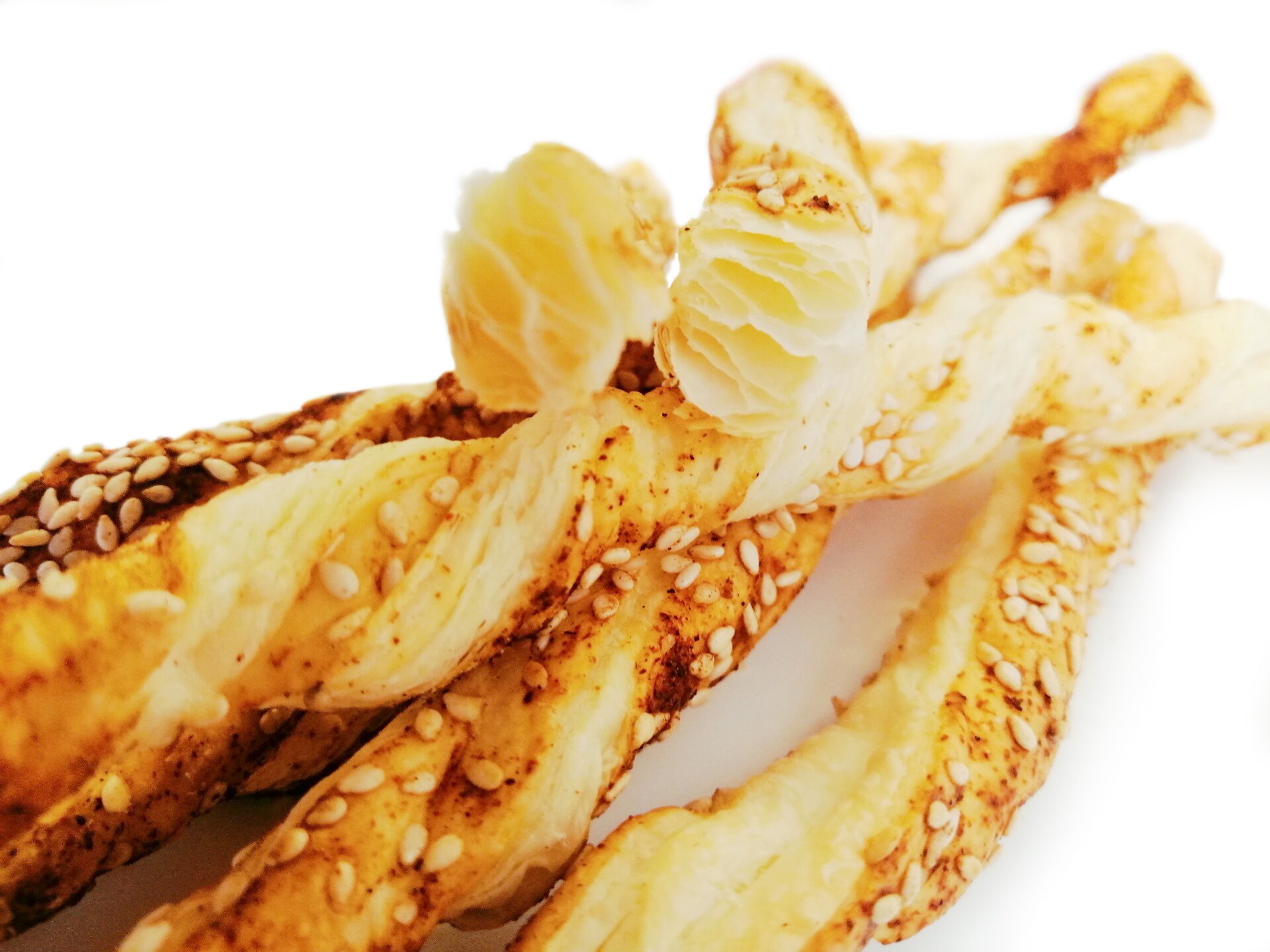 Zwinięte paluszki z ciasta, posypane sezamem.