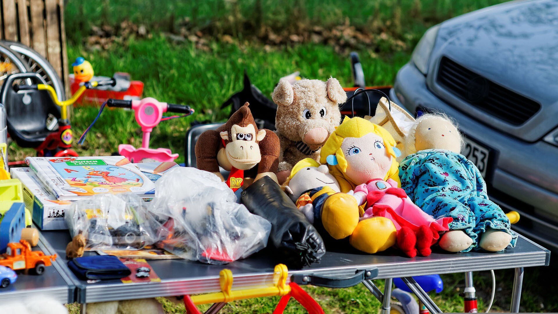 Zdjęcie przedstawia stanowisku na pchlim targu, na którym leżą zabawki.