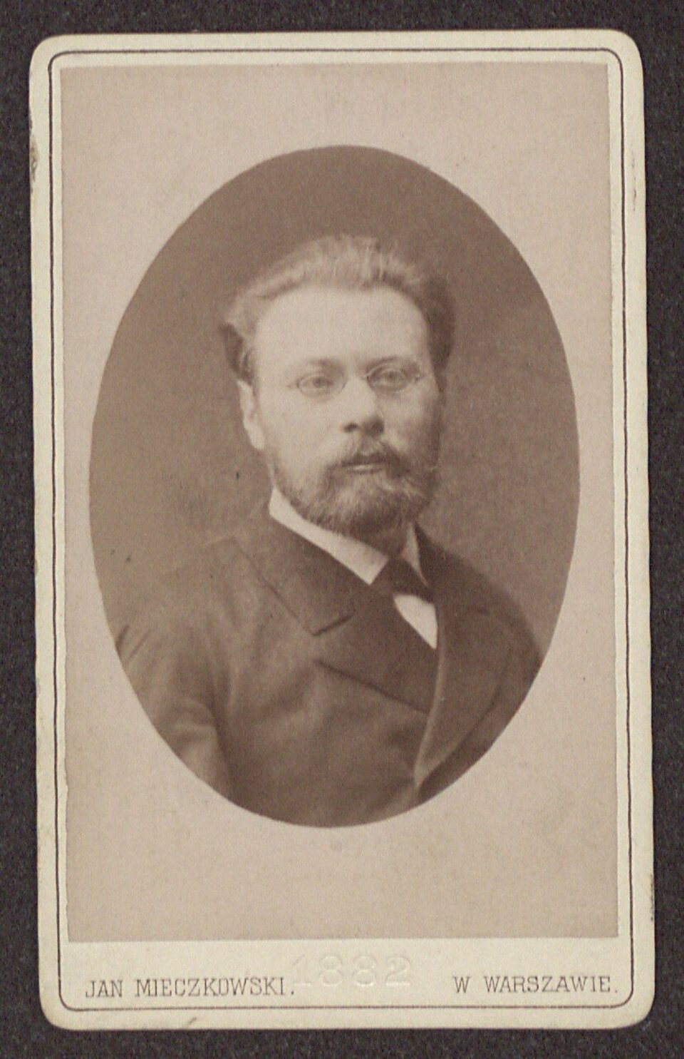 Ilustracja przedstawia dzieło, na którym został namalowany Zygmunt Noskowski. Utrzymana jest w kolorach sepii. Mężczyzna ma zaczesane do tyłu włosy, krótką brodę i małe okulary. Ubrany jest w ciemny garnitur i białą koszulę.