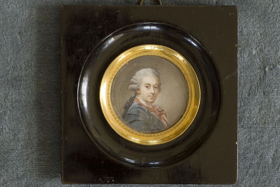 Ilustracja przedstawia miniaturę okrągłego portretu Marcello Bacciarellego, oprawionego w czarną ramę ze złoceniem od środka. Miniatura zamieszczona jest na ciemnym, kwadratowym tle, zawieszonym na szarej ścianie. Wizerunek ukazany jest jako popiersie ujęte z profilu, jednak z głową zwróconą frontalnie w stronę widza. Król ubrany jest w niebieski frak, spod którego wystaje biały kołnierz oraz przewiązana czerwona apaszka. Na głowie założoną ma perukę z lokami, spiętą z tyłu.