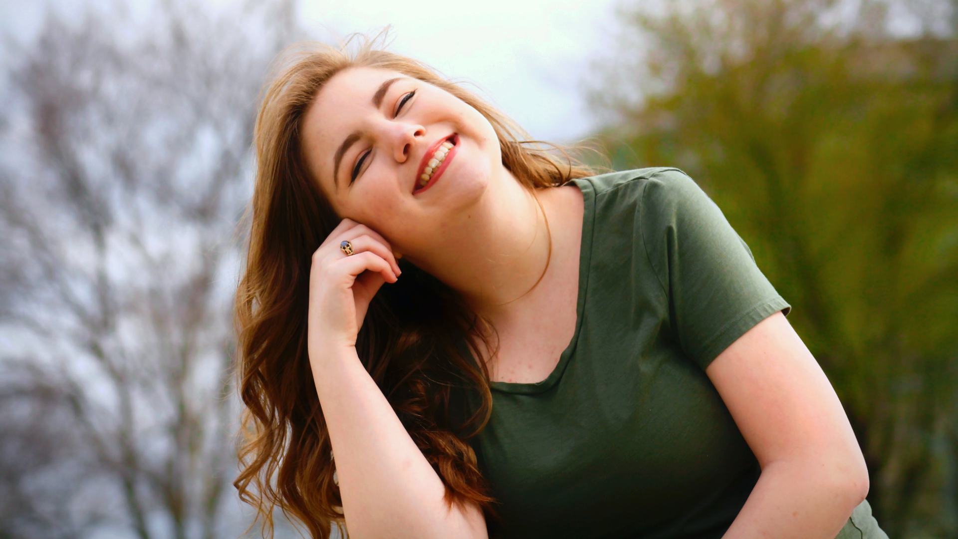 Zdjęcie przedstawia wesołą, uśmiechniętą dziewczynę.