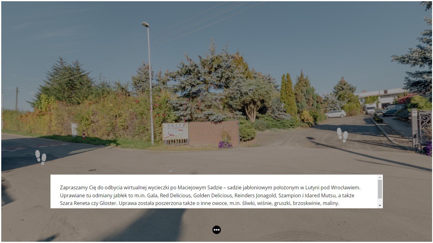 Widok planszy głównej, od której rozpoczyna się wycieczka. W tle widać drogę prowadzącą do gospodarstwa sadowniczego. Jest otoczona drzewami i krzewami. Na środku w białej ramce znajduje się tekst wprowadzający do wycieczki wirtualnej.