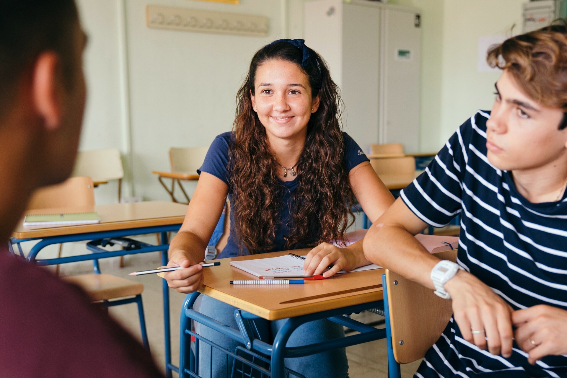 Zdjęcie przedstawia uczniów rozmawiających w klasie 