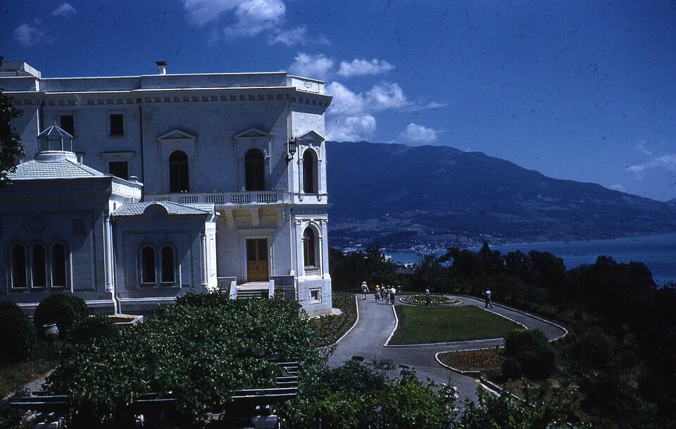 Zdjęcie przedstawia kompleks pałacowy usytuowany na wzgórzu u podnóża którego rozciąga się Morze Czarne. W oddali widać góry. Budynek wykonany jest z białego kamienia i marmuru i składa się z kilku połączonych ze sobą brył. Łączy w sobie różne style architektoniczne z przewagą włoskiego renesansu. Jest dwukondygnacyjny. Okna mają łukowaty kształt, a dachy są w przeważającej części są płaskie z wieńczącym gzymsem. Budynek usytuowany jest w ogrodzie pośród różnorodnej roślinności, a wokół niego są alejki spacerowe.