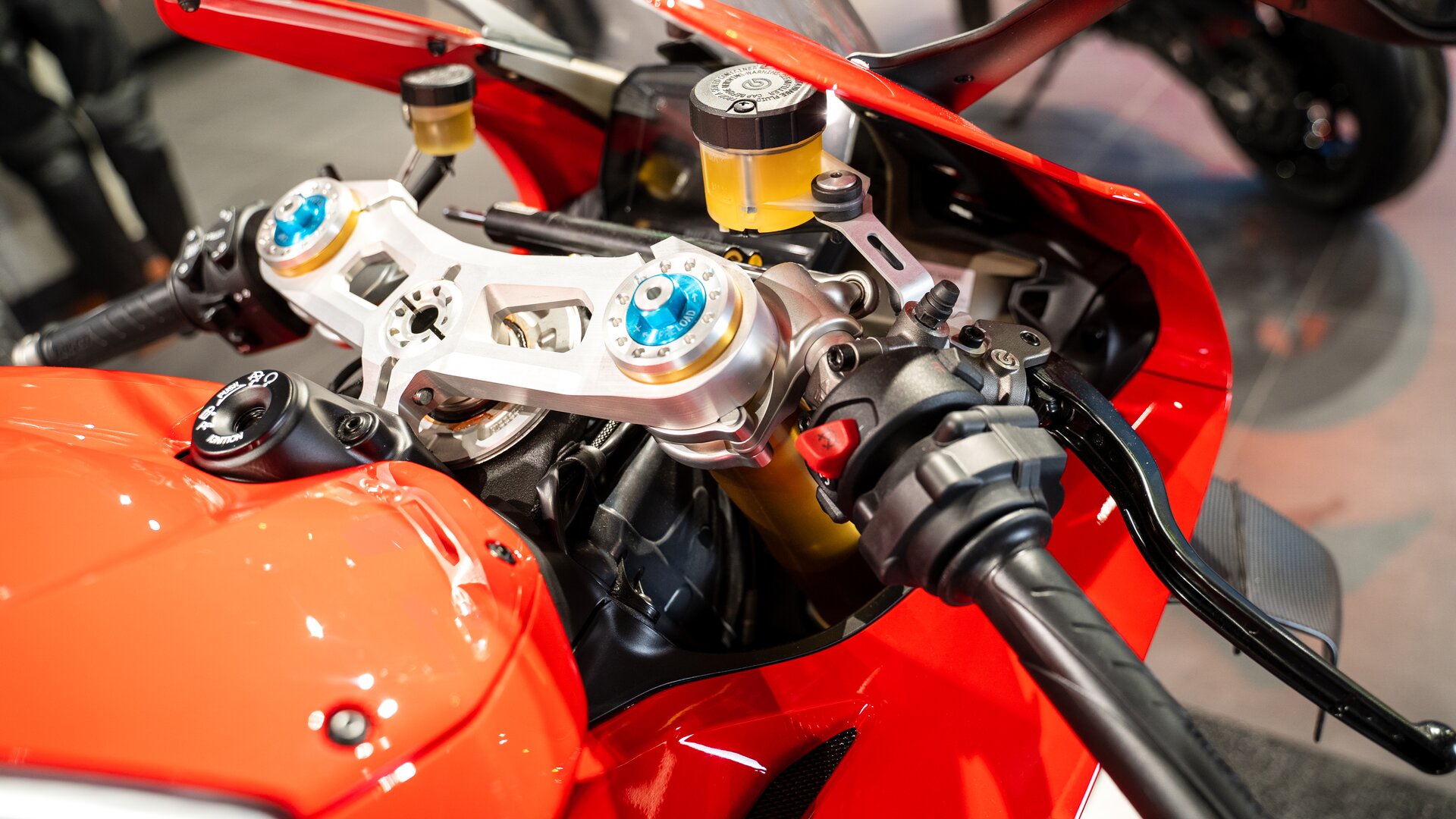 Zdjęcie pokazuje zbliżenie na kierownicę motocykla. Tam przyciski, wskaźniki, hamulce przy kierownicy. 