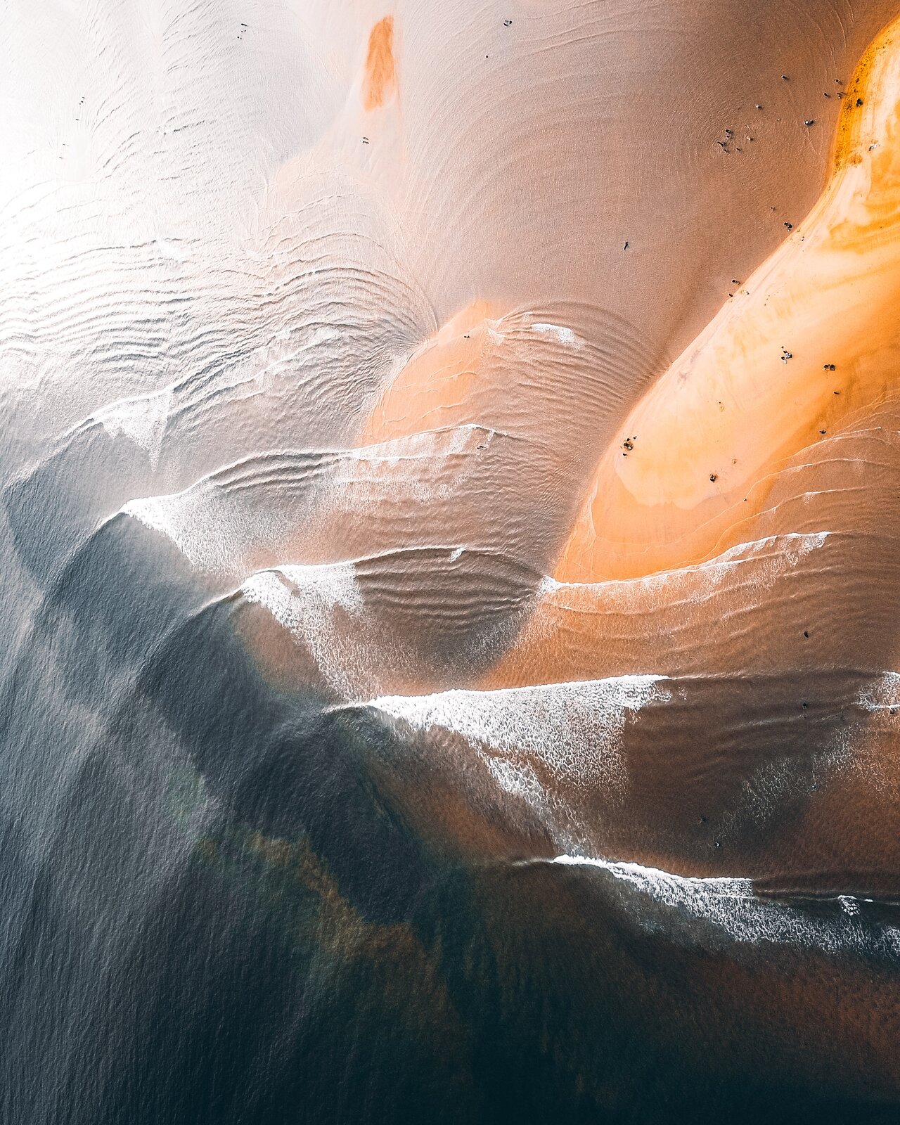 Rys. 2. Zdjęcie przedstawia dyfrakcję fal. Wykonano je z góry nad brzegiem oceanu. Fale wody natrafiając na piaszczysty brzeg ulegają ugięciu i tworzą charakterystyczny obraz w postaci łuków.