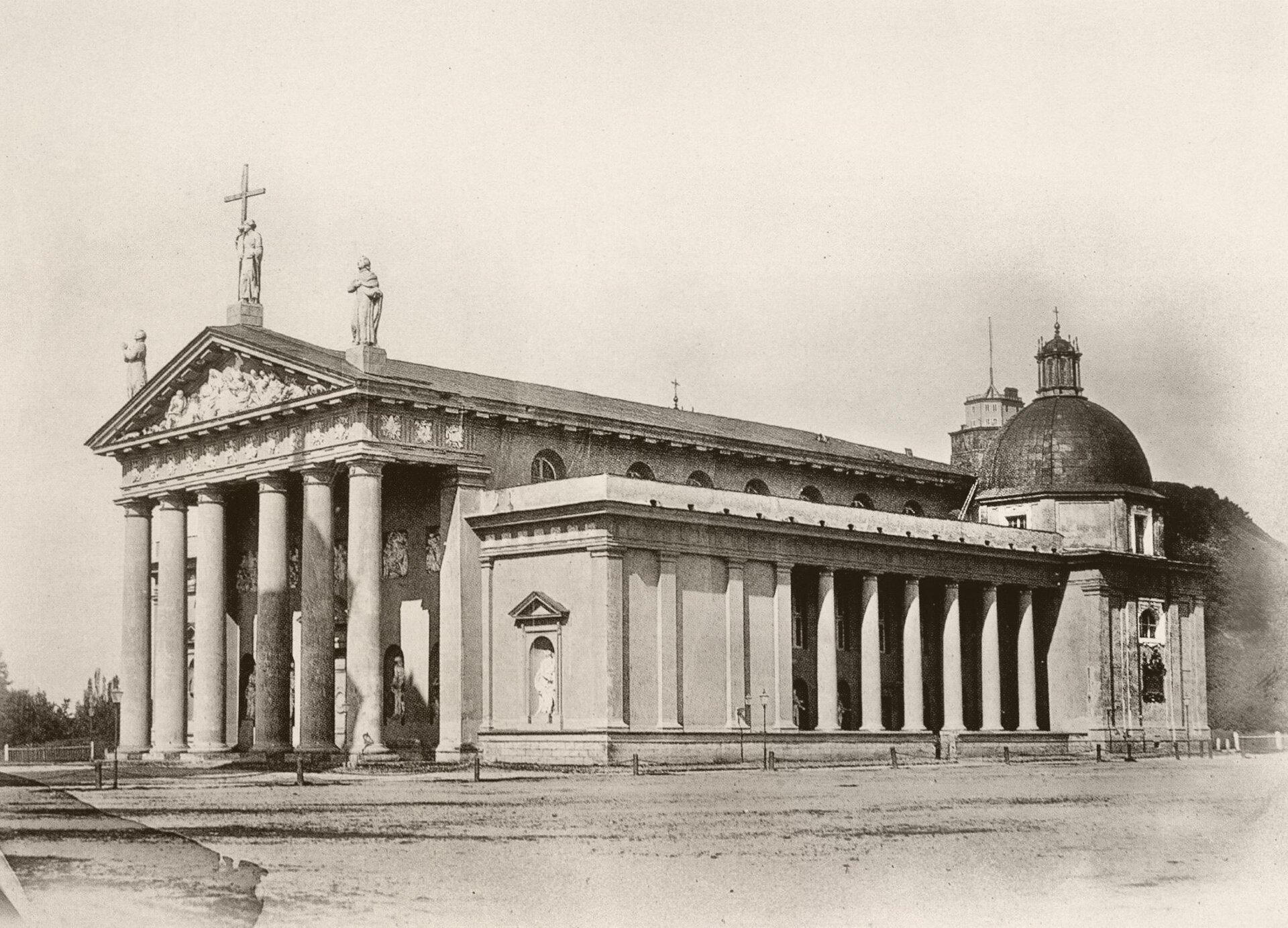 Kliknij, aby powiększyć Ilustracja przedstawia wygląd katedry wileńskiej po przebudowie w stylu klasycystycznym. Świątynia posiada prostokątną bryłę. Ma trójnawowy układ. Fasada frontowa ozdobiona została sześciokolumnowym portykiem. Na jej szczycie wznoszą się figury św. Kazimierza, św. Heleny z krzyżem i św. Stanisława. Duża kompozycja figuralna w tympanonie przedstawia ofiarę Noego. Między pilastrami budynku stoją posągi.