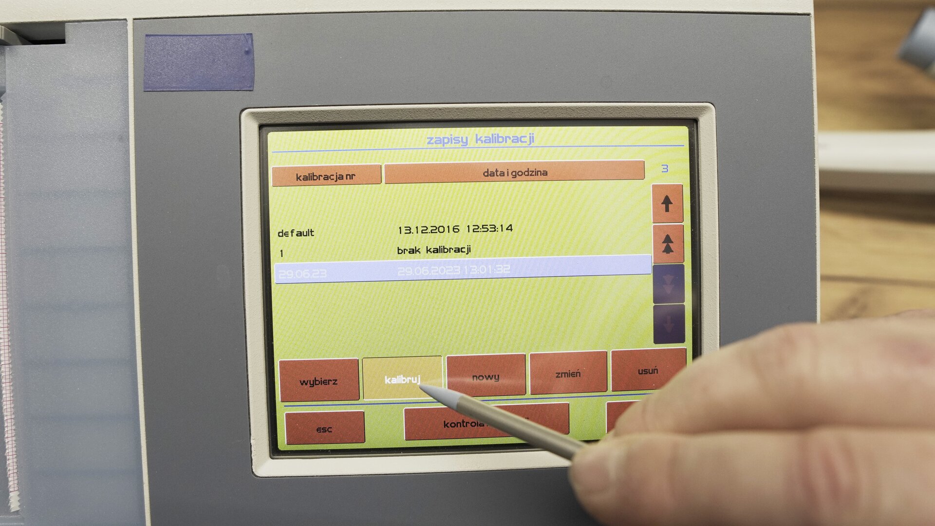 Na zdjęciu pokazano przybliżenie ekranu spirometru. Technik wybiera na klawiaturze ekranowej przycisk kalibruj.