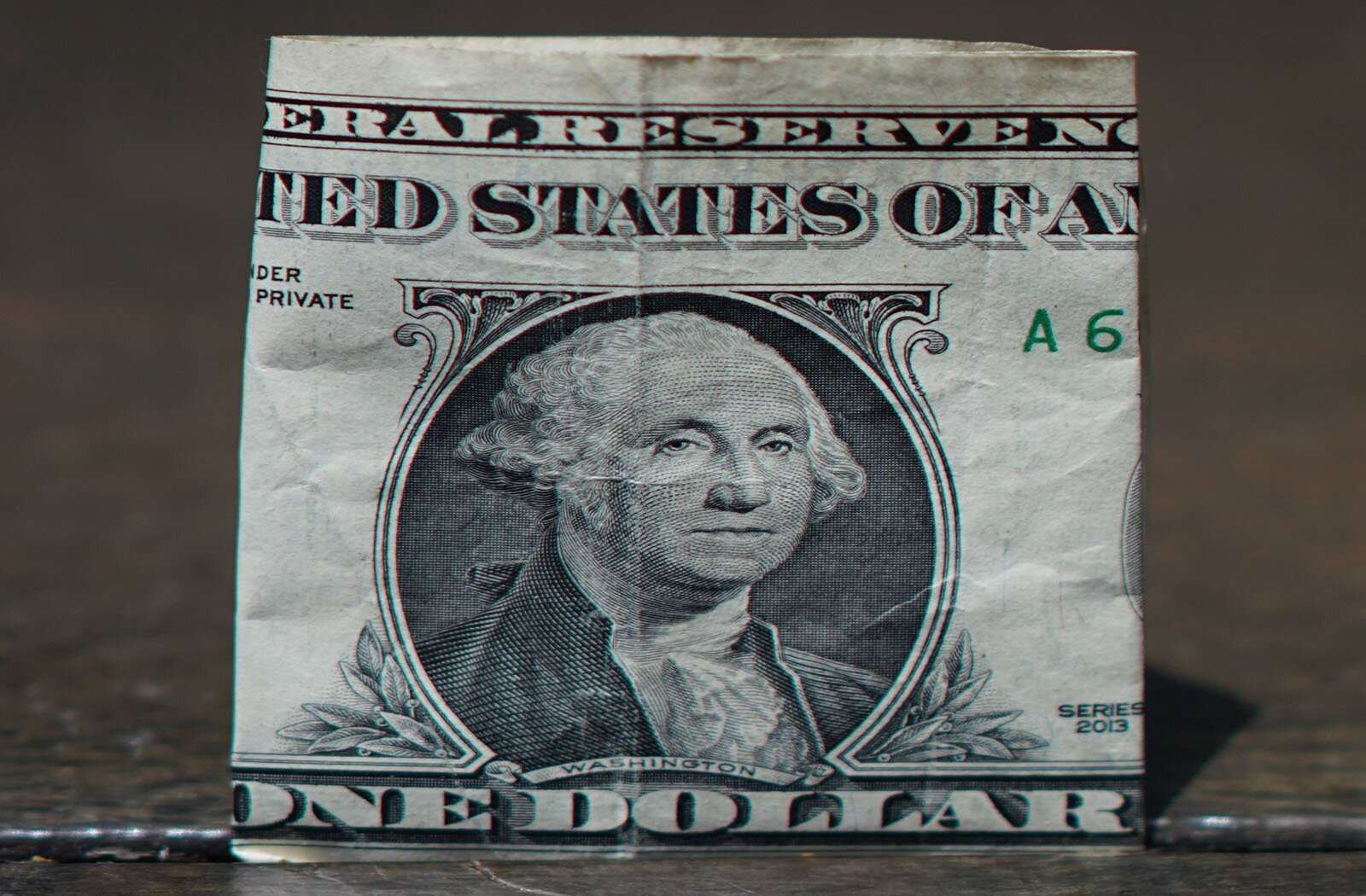 Zdjęcie przedstawia banknot jedno dolarowy ze zbliżeniem na twarz Jerzego Waszyngtona. 