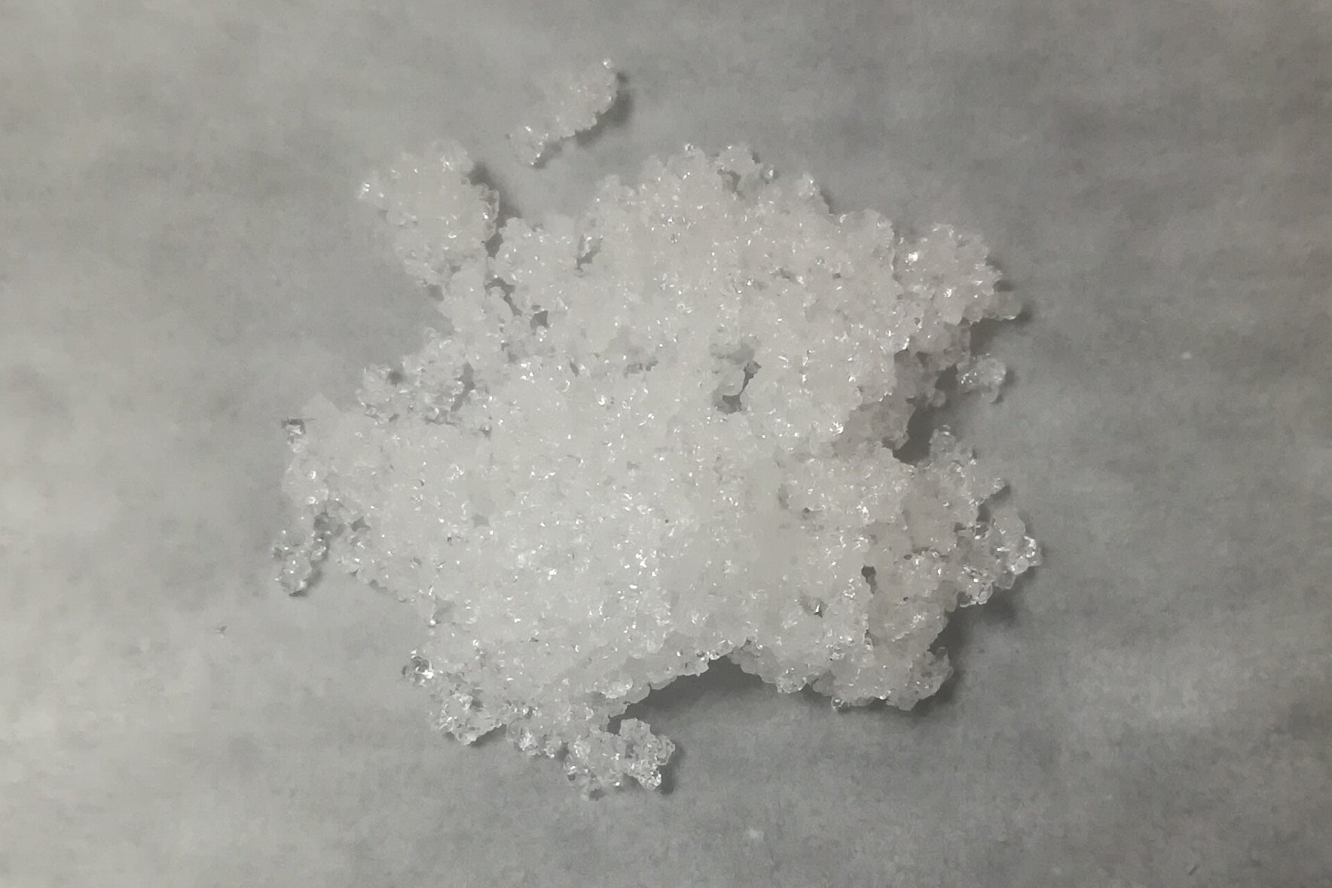 Ilustracja przedstawia zlepione, białe kryształy.