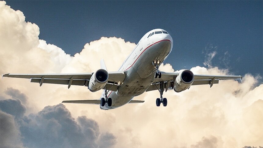 Ilustracja przedstawia lecący samolot na niebie.