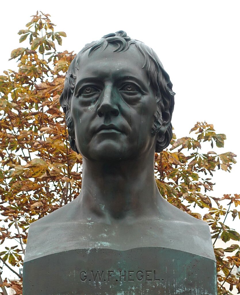 Zdjęcie przedstawia fragment pomnika. Widoczne jest popiersie dojrzałego mężczyzny o owalne twarzy.