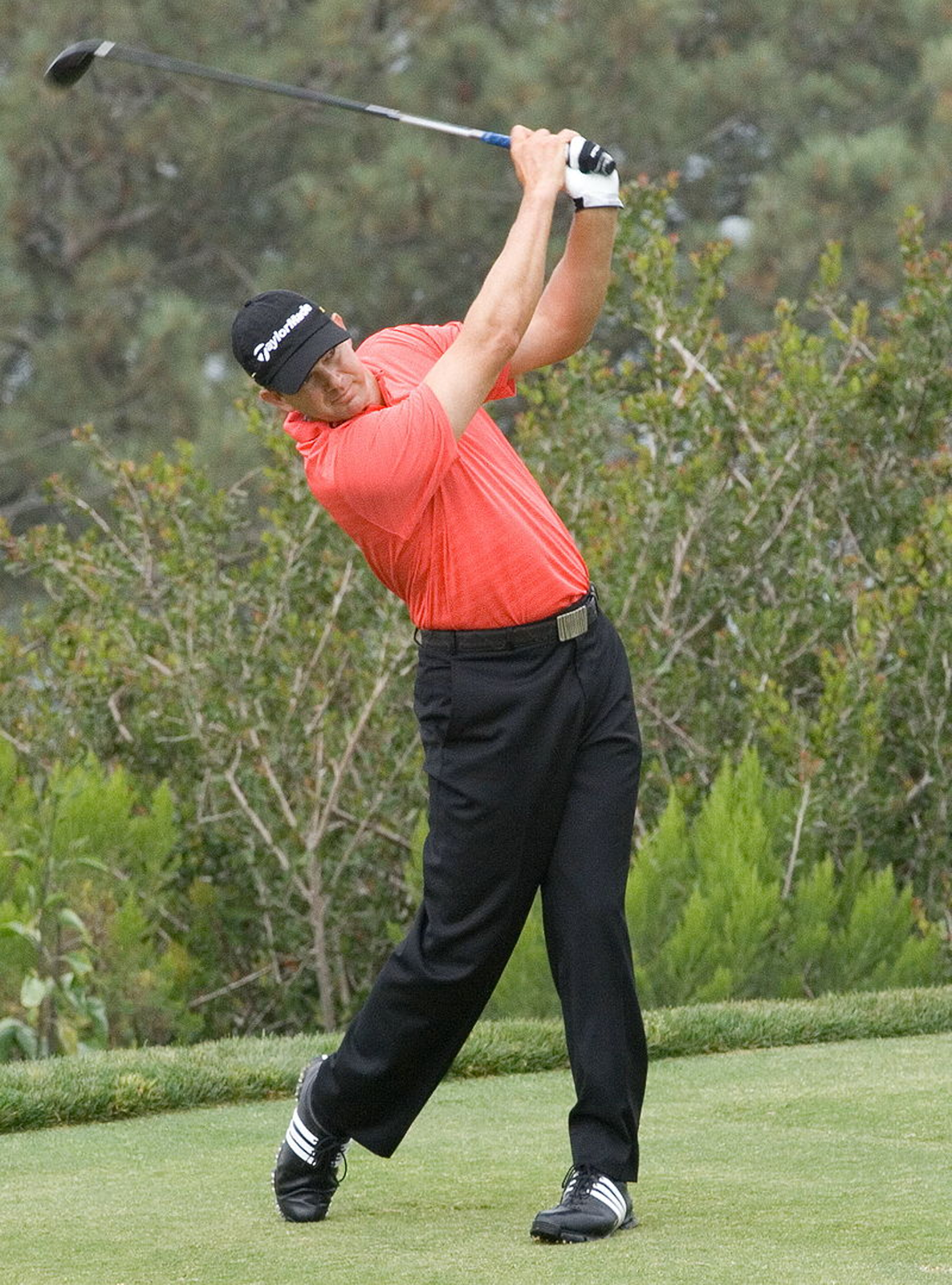 Rys. 5. Zdjęcie przedstawia golfistę z kijem w rękach uniesionym nad głową tuż po wybiciu piłeczki. Sylwetka golfisty wygięta jest w charakterystyczny lekki łuk dla wzmocnienia skuteczności wybicia piłeczki.
