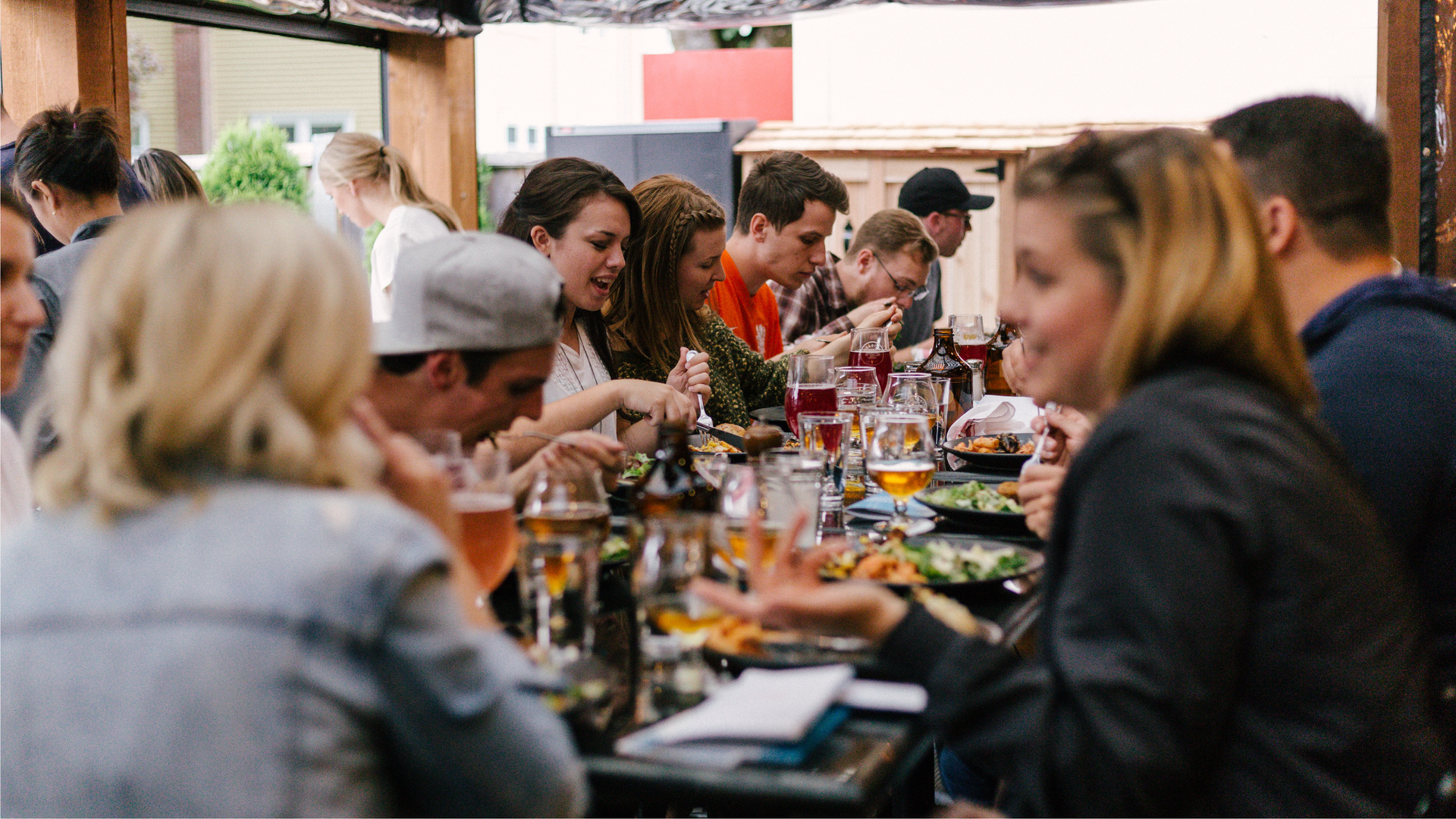 Zdjęcie przedstawia grupę ludzi siedzących przy suto zastawionym stole.