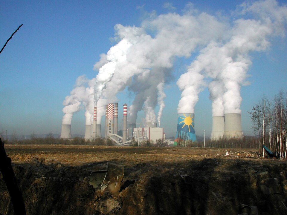 Zdjęcie przedstawia chłodnie kominowe i kominy w Elektrowni Turów. Kominy są cienkie, chłodnie są masywniejsze i posiadają większy obwód. Ze wszystkich z nich wydobywa się gęsta para.  