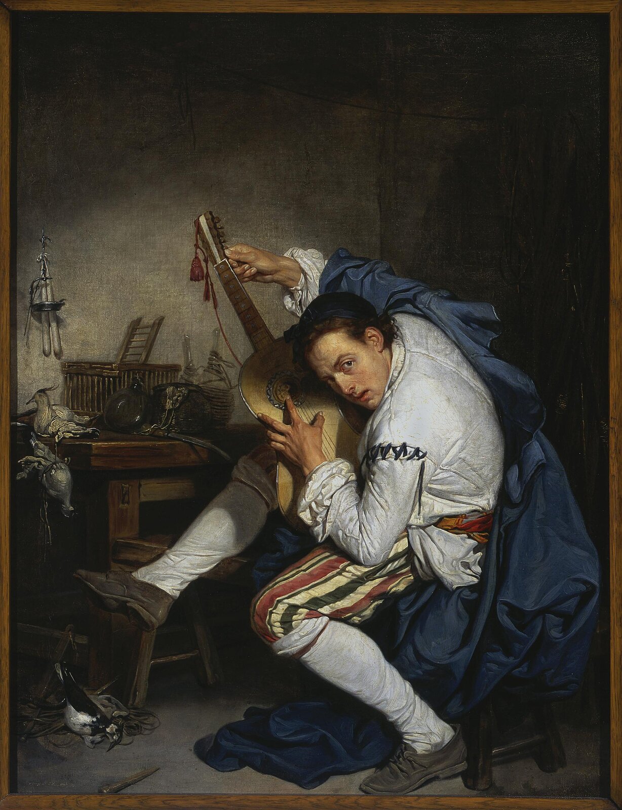 Ilustracja przedstawia dzieło pt. „Gitarzysta” autorstwa Jean‑Baptiste Greuze. Jest to obraz olejny na płótnie (64x48 cm) namalowany ok. 1757. Widać na nim młodego mężczyznę, który stroi gitarę. Przedstawione w tle przedmioty świadczą o tym, że mężczyzna jest łowcą ptaków.