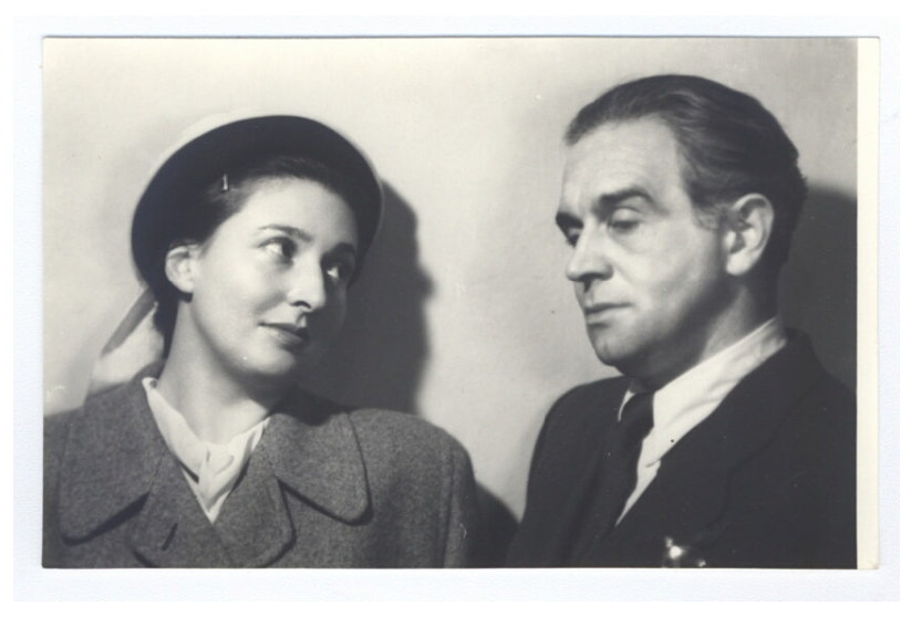 Zdjęcie przedstawia parę - kobietę i mężczyznę. Stoją obok siebie, kobieta patrzy głęboko w oczy mężczyźnie.