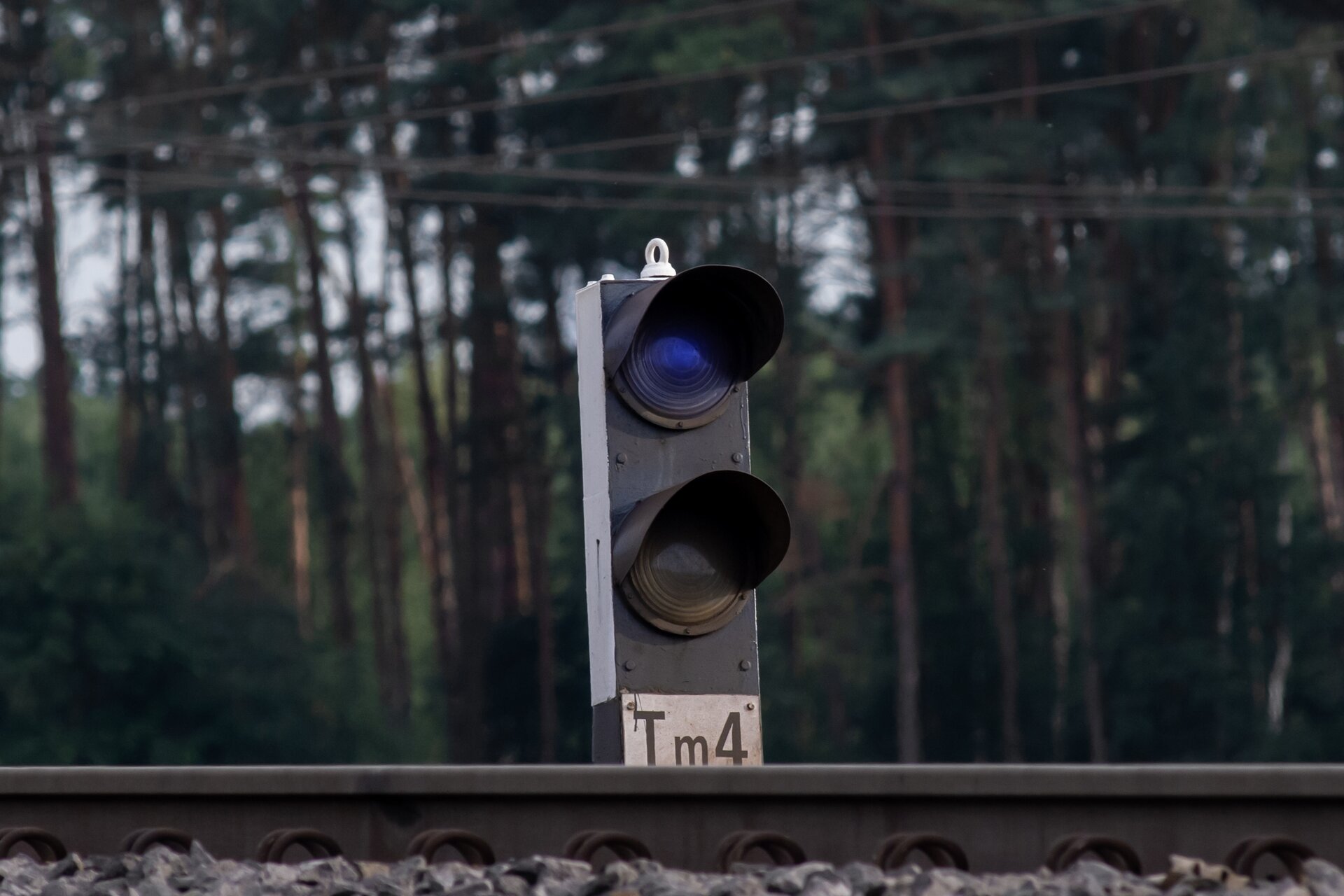 Zdjęcie przedstawia niską tarczę manewrową karzełkową. Znajdują się na niej dwa sygnalizatory. Górny świeci się na kolor niebieski co znaczy, że jazda manewrowa jest zabroniona. 