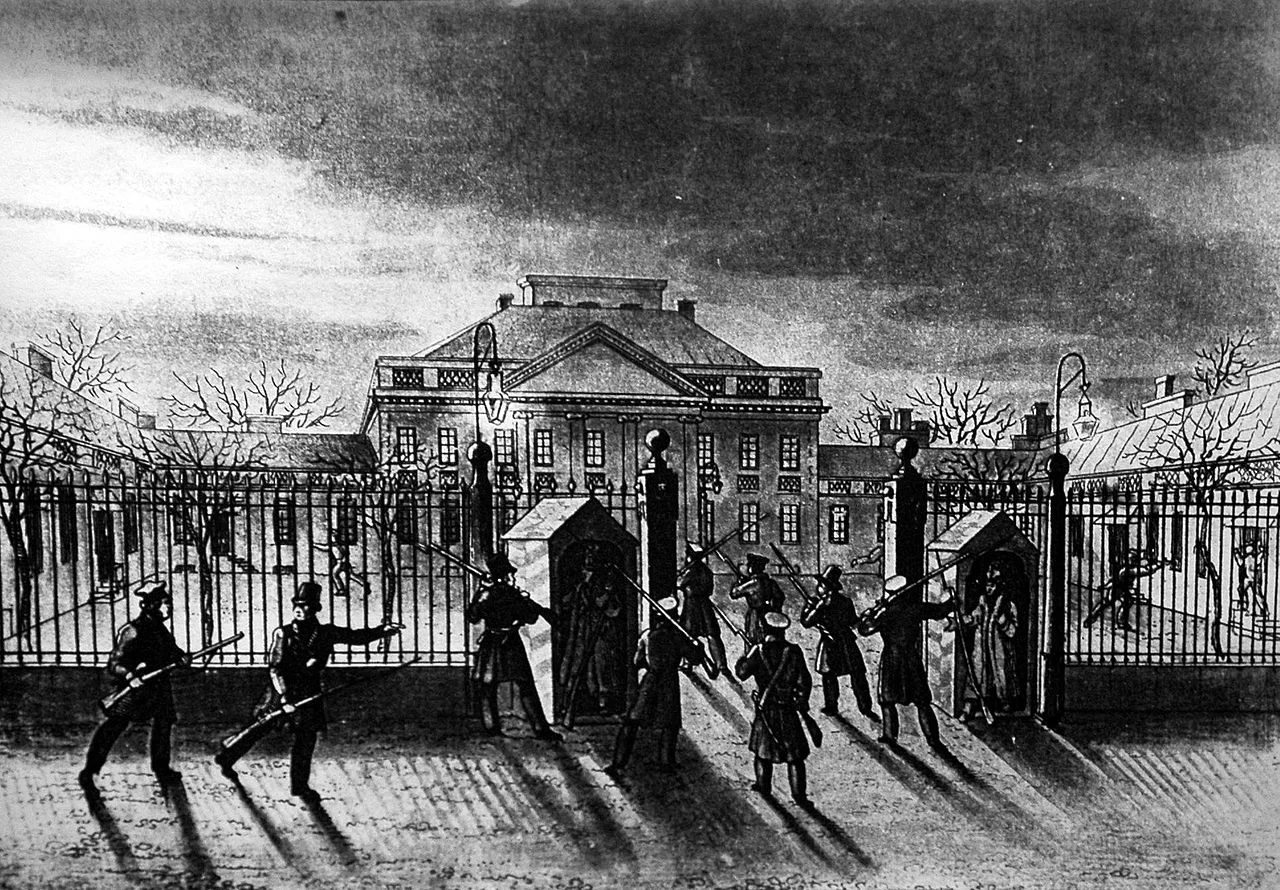 Ilustracja przedstawia budynek otoczony wysokim płotem. Fasadę budynku zwieńcza trójkątny fronton. W otwartej bramie i przed ogrodzeniem znajdują się uzbrojeni w strzelby mężczyźni. Wokół budynku rosną drzewa, pozbawione są liści.