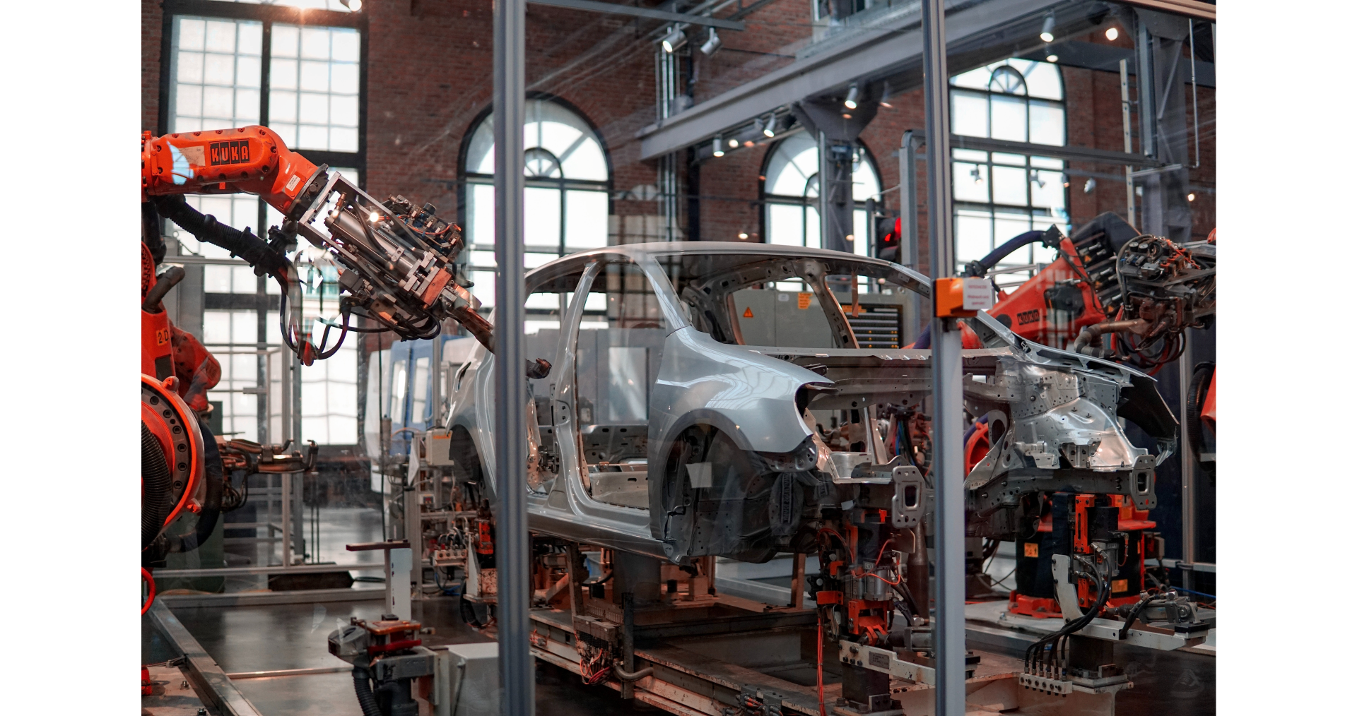 Ramiona robota spawającego ramę samochodu na stanowisku montażowym w fabryce aut.