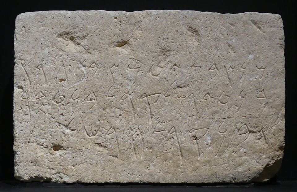 Zdjęcie przedstawia kamienną tablicę z wyrytymi w niej napisami w alfabecie fenickim.