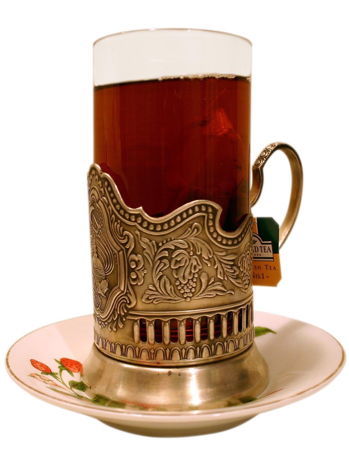 Fotografia przedstawiająca wysoką szklankę z uchem, w której znajduje się ciemnobrązowy płyn.