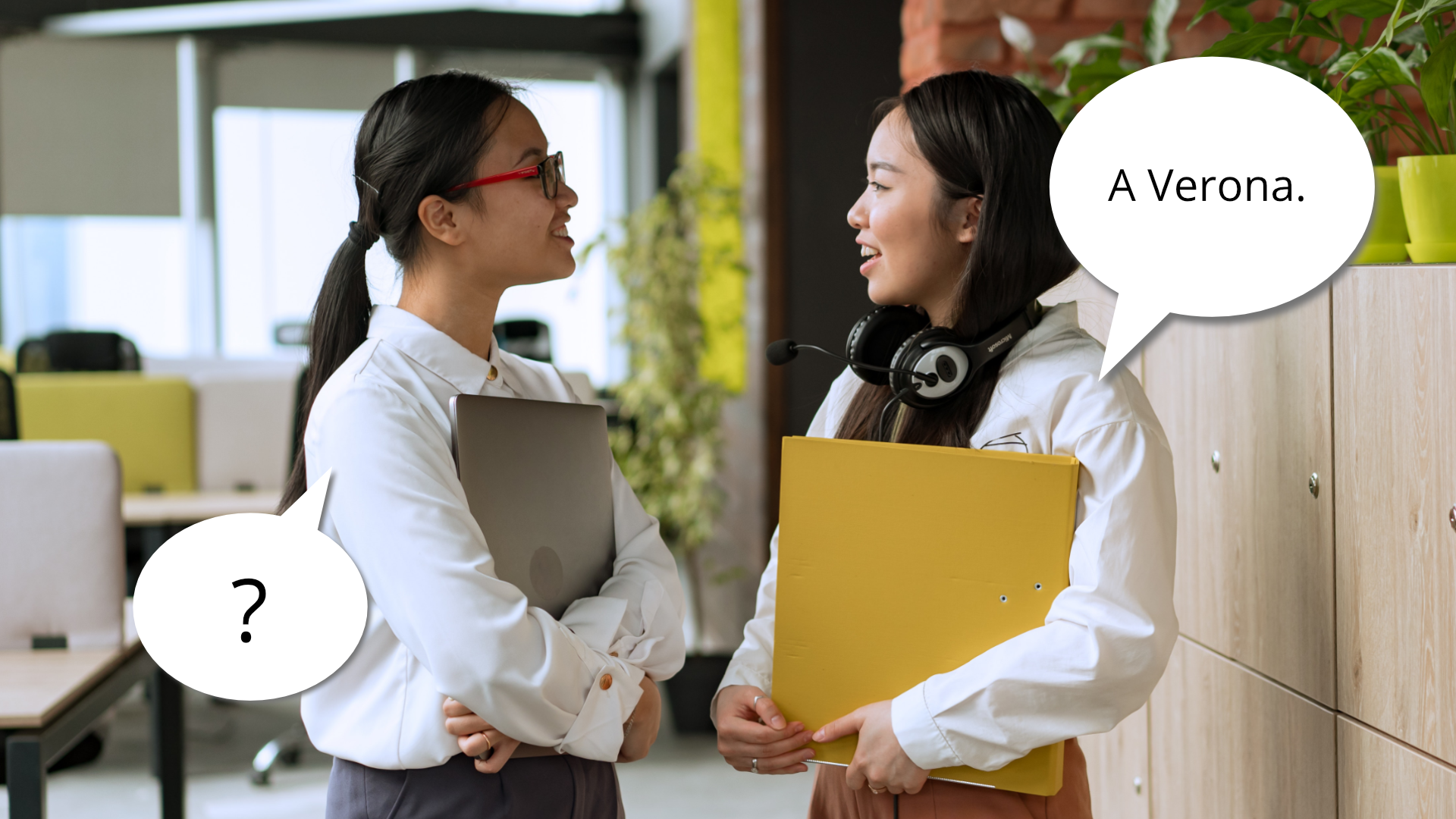 Zdjęcie przedstawia dwie uśmiechnięte, stojące naprzeciwko siebie dziewczyny. Obok dziewczyny po lewej znajduje się dymek ze znakiem zapytania. Obok dziewczyny po prawej znajduję się dymek z tekstem: "A Verona."