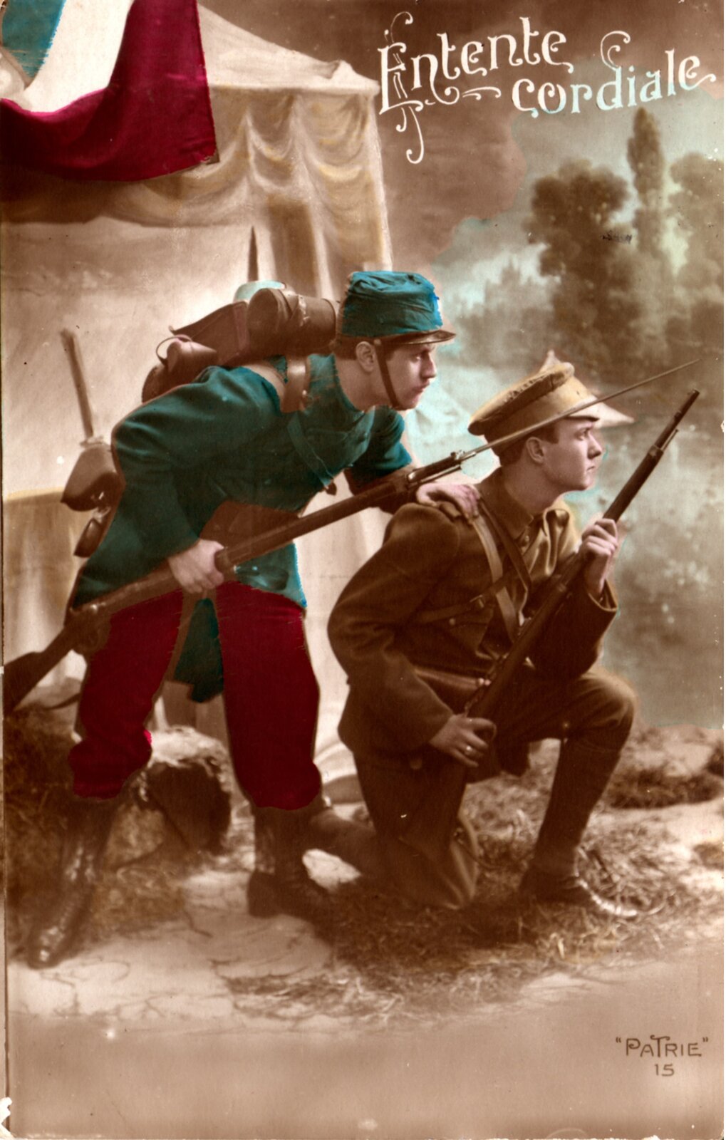 Ilustracja przedstawia dwóch młodych żołnierzy z bronią. Żołnierzy po prawej ma brązowy mundur i przykuca. Żołnierz po lewej ma niebieski mundur, stoi za pierwszym żołnierzem i dotyka jego ramienia. Obydwaj patrzą w prawą stronę zdjęcia. Za nimi znajduje się namiot, w tle widoczne są smugi dymu. Na górze plakatu jest napis w języku francuskim: Entente Cordiale.
