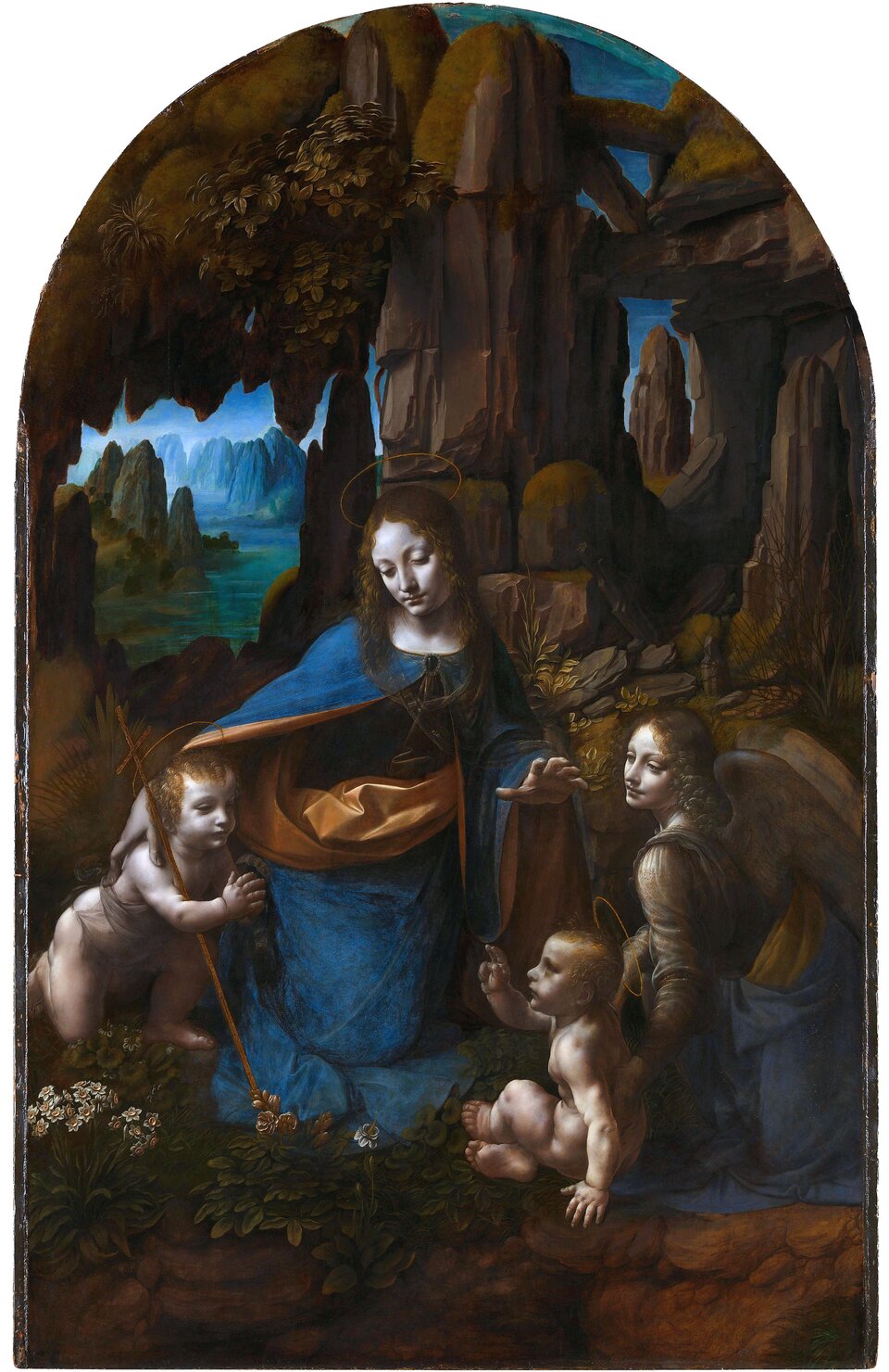 Ilustracja przedstawia obraz Leonarda da Vinci „Madonna w grocie”. Ukazuje Madonnę z Jezusem i św. Janem Chrzcicielem oraz aniołem na tle groty skalnej, przez którą prześwituje pejzaż z rzeką i górami w tle. Madonna ma na sobie błękitny płaszcz, prawą ręką obejmuje znajdującego się po lewej stronie Jana Chrzciciela, lewą dłoń trzyma nad głową Jezusa, który siedzi, zwrócony w stronę Jana. Z boku, po prawej stronie siedzi anioł, który lewą dłoń trzyma na plecach Jezus. Na pierwszym planie znajduje się bujna, przyziemna roślinność. Za postaciami skalista grota z prześwitem po lewej stronie, za którym rozciąga się widok na rzekę i góry w tle oraz błękitne, pogodne niebo. Dodatkowo na ilustracji umieszczono następujące informacje: