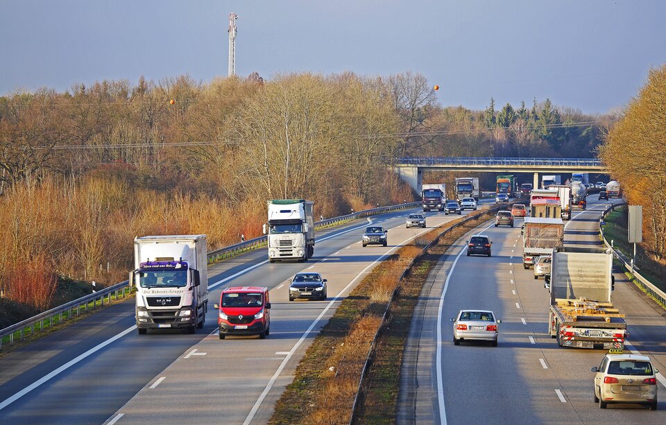 Zdjęcie przedstawia autostradę, po której jadą liczne samochody. Po lewej i prawej stronie autostrady rośnie las. 