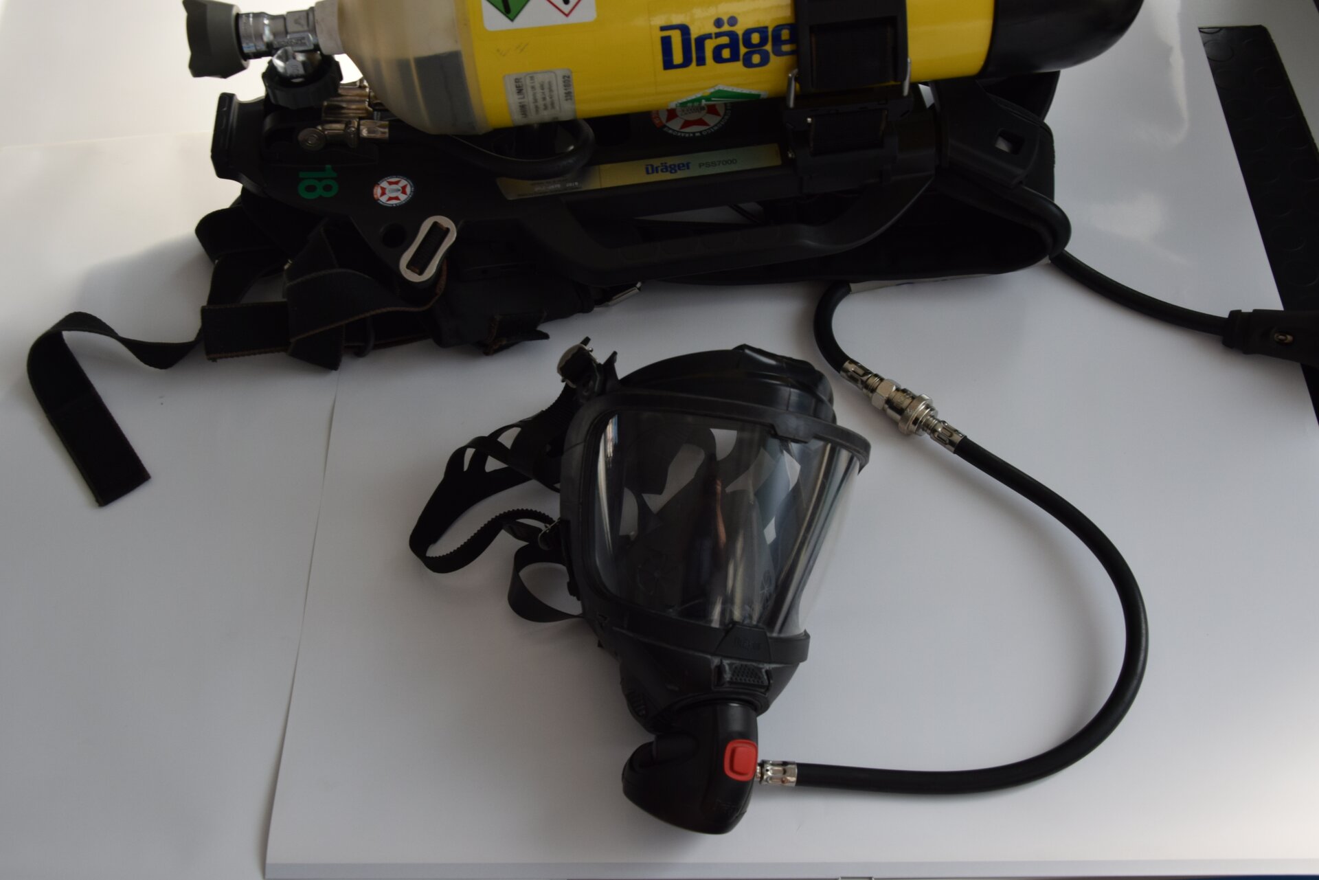 Na zdjęciu widoczna jest maska z aparatem oddechowym. Maska jest w kształcie stożka. Powierzchnia boczna składa się z plastikowej szybki. Do dołu maski przyłączony jest czarny wężyk. Wężyk połączony jest z żółtą butlą widoczną w tle zdjęcia.Poniżej zdjęcia w prawym dolnym rogu widoczny jest przycisk odtwarzania. Tekst nagrania jest zgodny z tytułem zdjęcia.