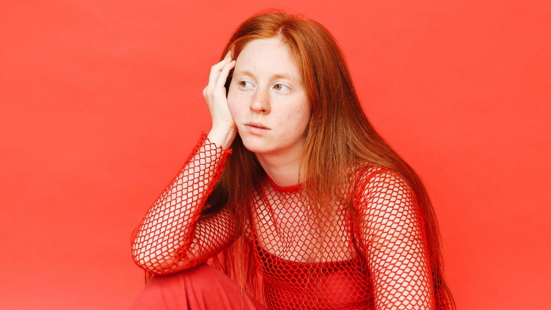 Zdjęcie przedstawia młodą, smutną dziewczynę z długimi włosami.