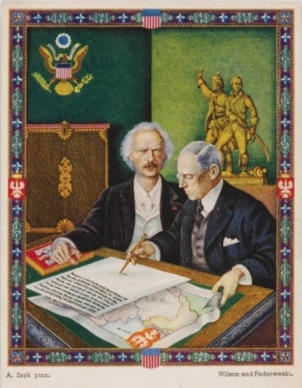 Barwna pocztówka zatytułowana „Wilson and Paderewski”, przedstawiająca obu mężczyzn siedzących przy stole, na którym leży duża zapisana do połowy karta a pod nią - mapa. Wilson wskazuje coś pisakiem na niezapisanej połowie karty. Jest to pocztówka z cyklu „Obrazy z chlubnych dni braterstwa polsko‑amerykańskiego”, ze zbiorów Muzeum Narodowe w Warszawie.