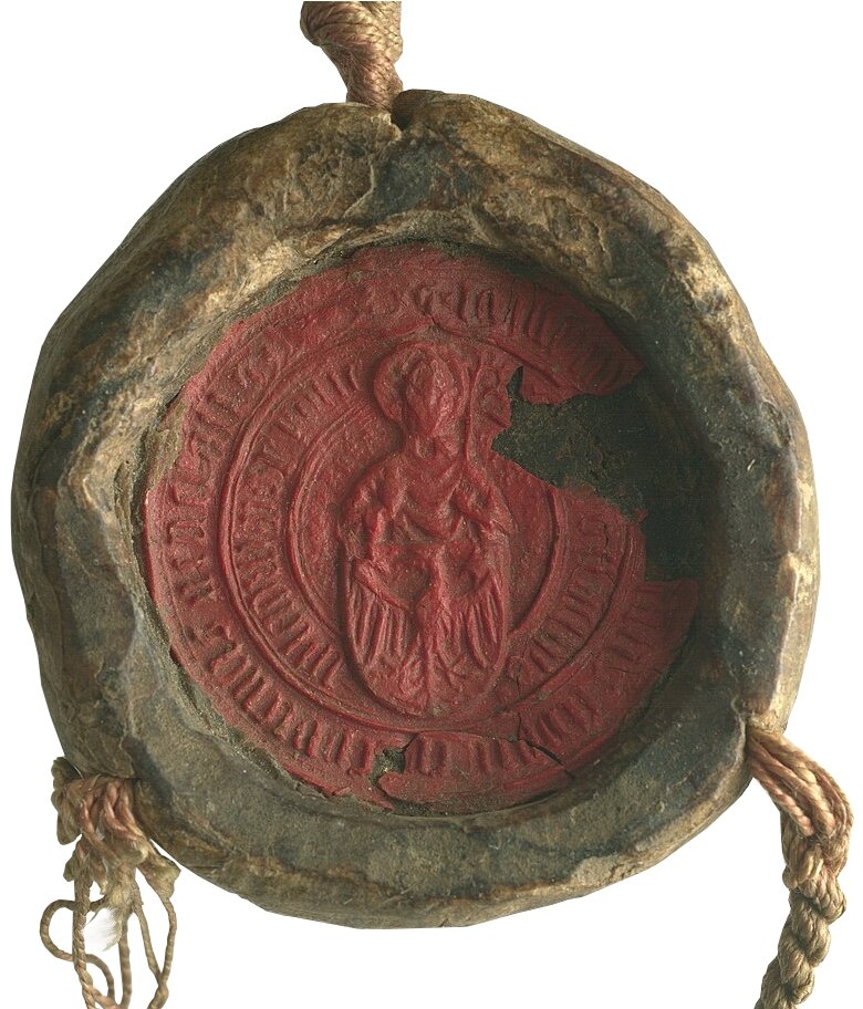 Zdjęcie przedstawia pieczęć Akademii Krakowskiej. Na jej środku znajduje się postać. Przed nią jest orzeł na traczy. Środek pieczęci jest czerwony. Obwódka pieczęci jest twarda i brązowa. Z trzech stron przewiązana jest sznurkiem.