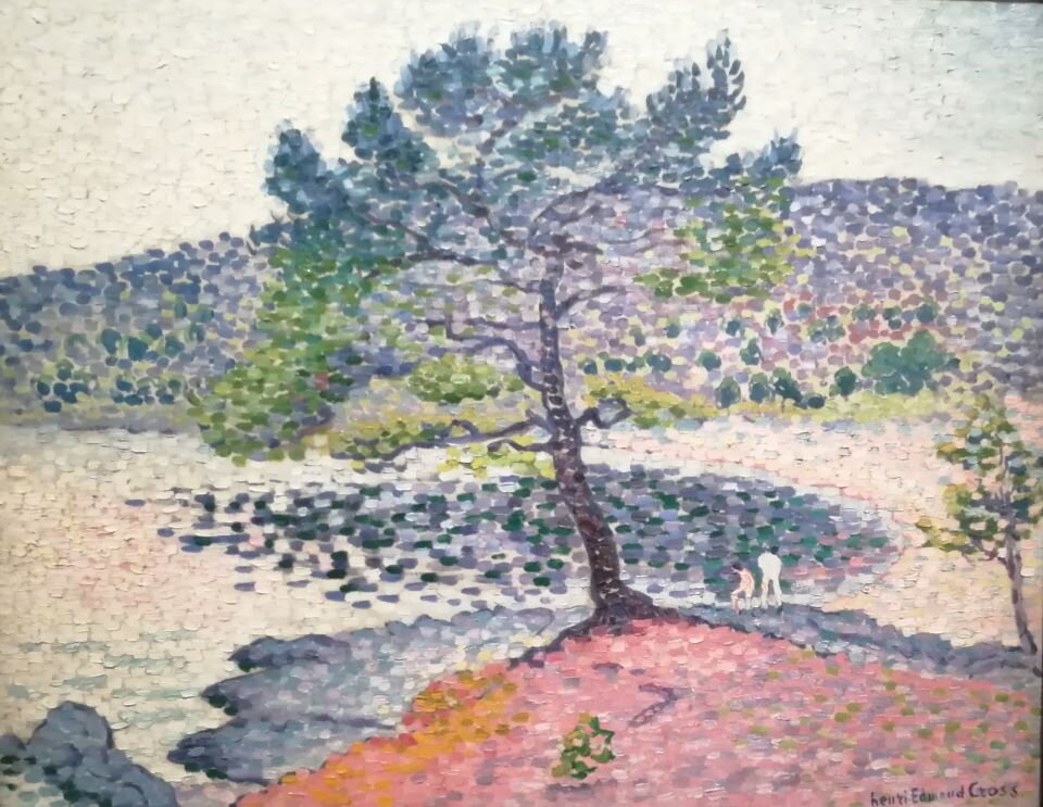 Ilustracja przedstawia fotografię obrazu, na którym znajduje się drzewo. Drzewo jest w centrum kompozycji, na pierwszym planie, na niewielkim wzniesieniu. W tle widać niewysokie pasmo górskie. Pomiędzy drzewem a górami widoczne jest jezioro. Faktura obrazu jest bardzo zróżnicowana, widać wyraźnie ślady pędzla w kształcie przypominającym kropki.