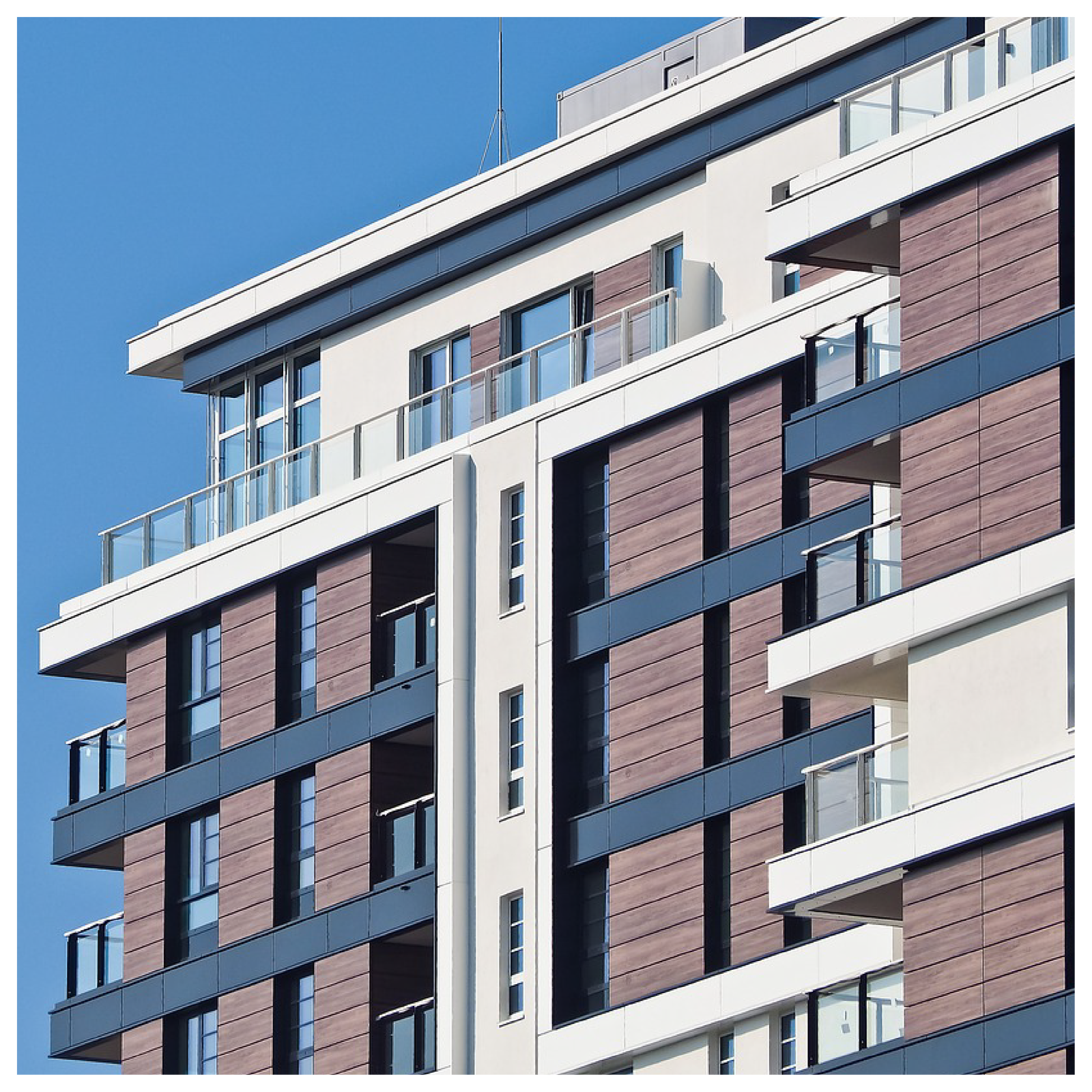 Zdjęcie przedstawia nowoczesny blok mieszkaniowy. 