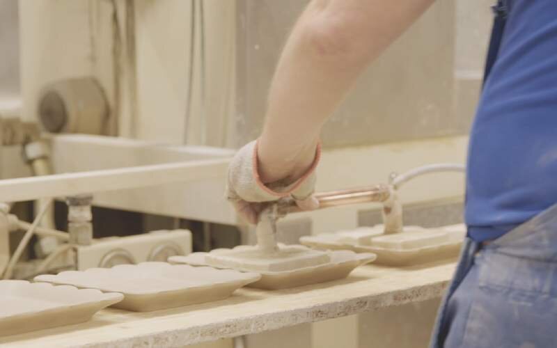 Krok szósty. Klasyfikacja wyrobów ceramicznych. Siódme zdjęcie przedstawia mężczyznę odkładającego wyroby na blat.