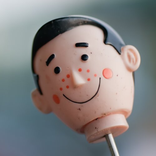 Fotografia główki lalki na patyku.