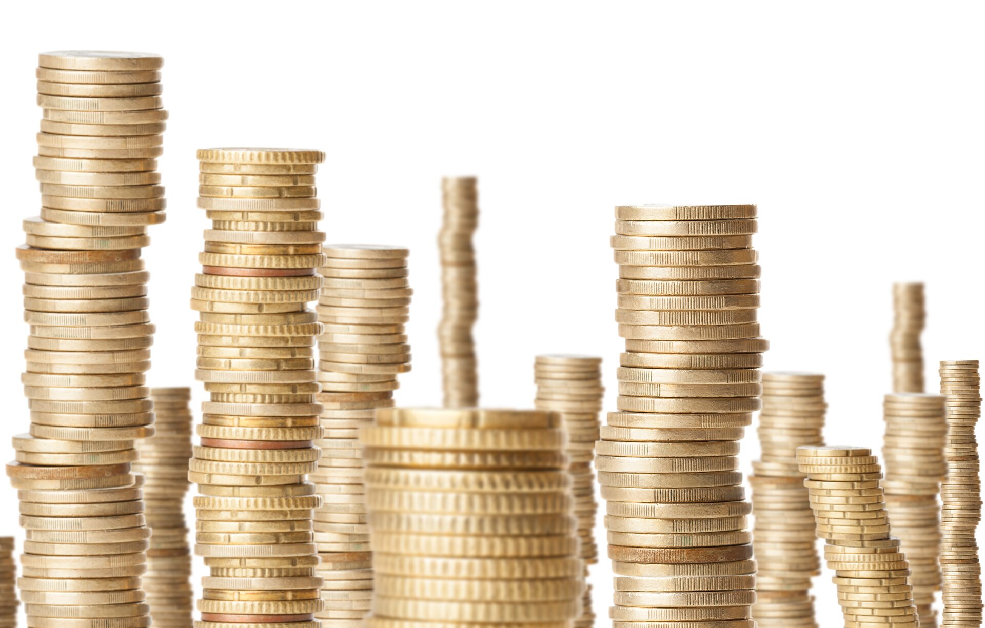 Zdjęcie ukazuje ustawione obok siebie stosy złotych monet. Stosy mają różną wysokość, a ich rozmieszczenie nadaje obrazowi poczucie głębi.