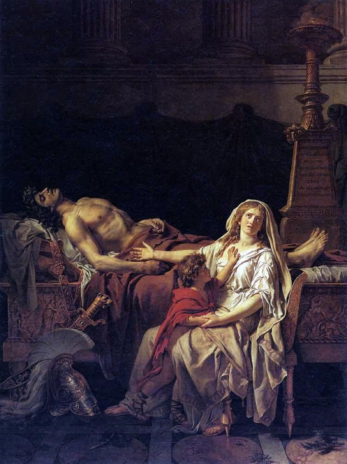 Ilustracja przedstawia obraz „Andromacha opłakująca Hektora”, którego autorem jest Jacques‑Louis David. Na środku obrazu, na ozdobnym łożu, na białym materiale leży czarnowłosy mężczyzna. Dolna połowa ciała przykryta jest brązowym materiałem. Przed łożem, z lewej strony stoi złoty hełm z białym pióropuszem i miecz. Przed łożem, z prawej strony na złotym, ozdobnym krześle siedzi kobieta. Ma długie, kręcone, jasne włosy. Ubrana jest w białe szaty, a na głowie ma białą chustę. Między jej nogami stoi kilkuletni chłopiec o brązowych, kręconych włosach. Ma na sobie czerwoną szatę. Z prawej strony za łożem stoi wysoka, wąska, brązowa rzeźba. Tło jest ciemne, niewyraźne.